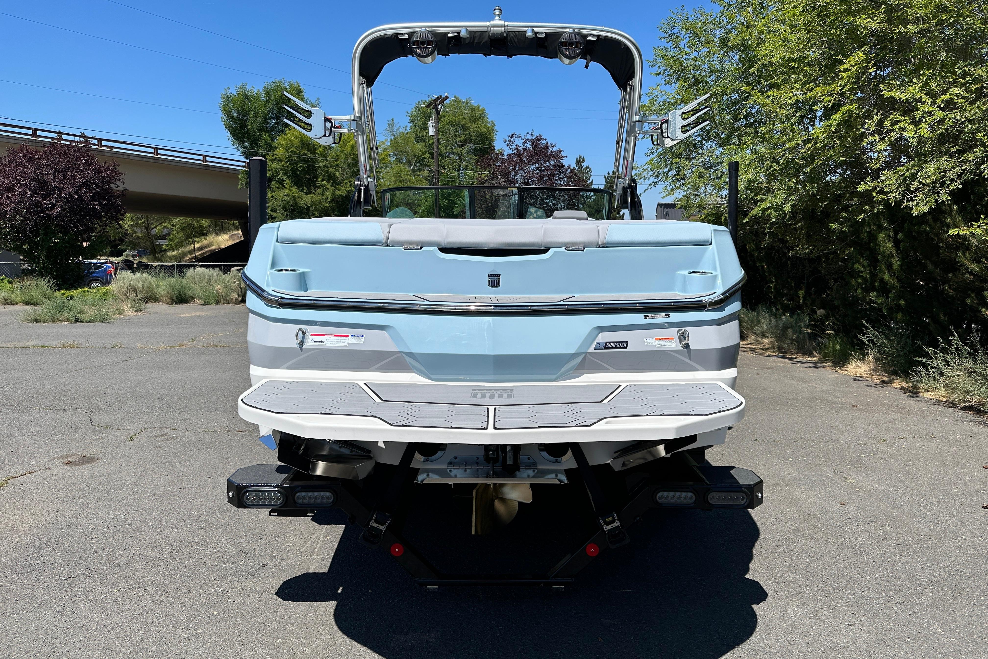 2023 MasterCraft NXT23 boat, rear view, parked outdoors on a sunny day.
