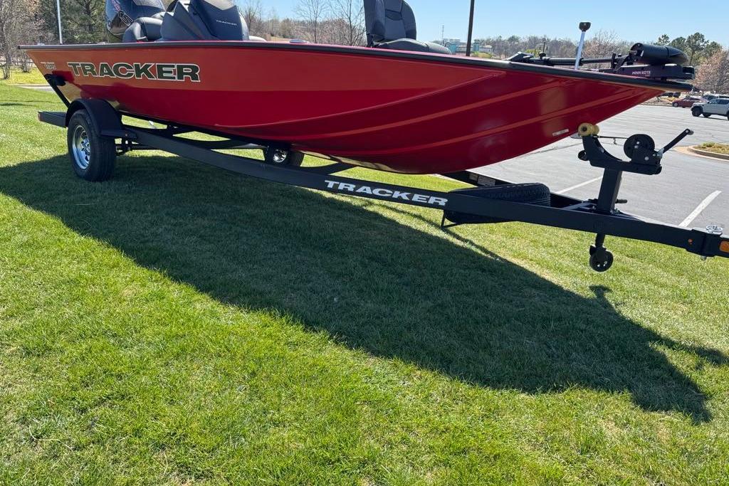 Red 2026 Tracker Pro Team 195 boat on trailer, parked on grass.