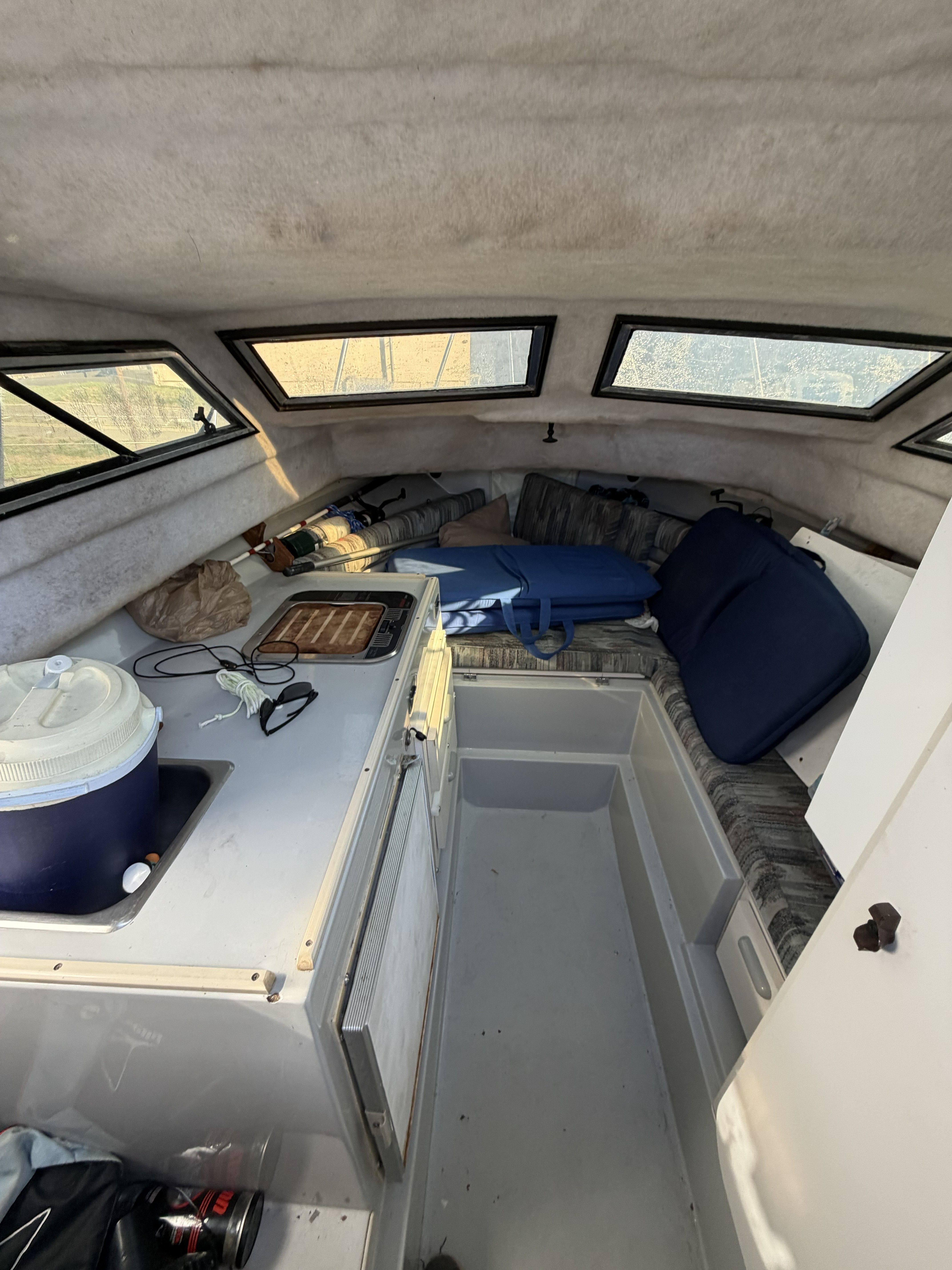 Interior of a 1989 Wellcraft 250 Sportsman with seating area and windows.