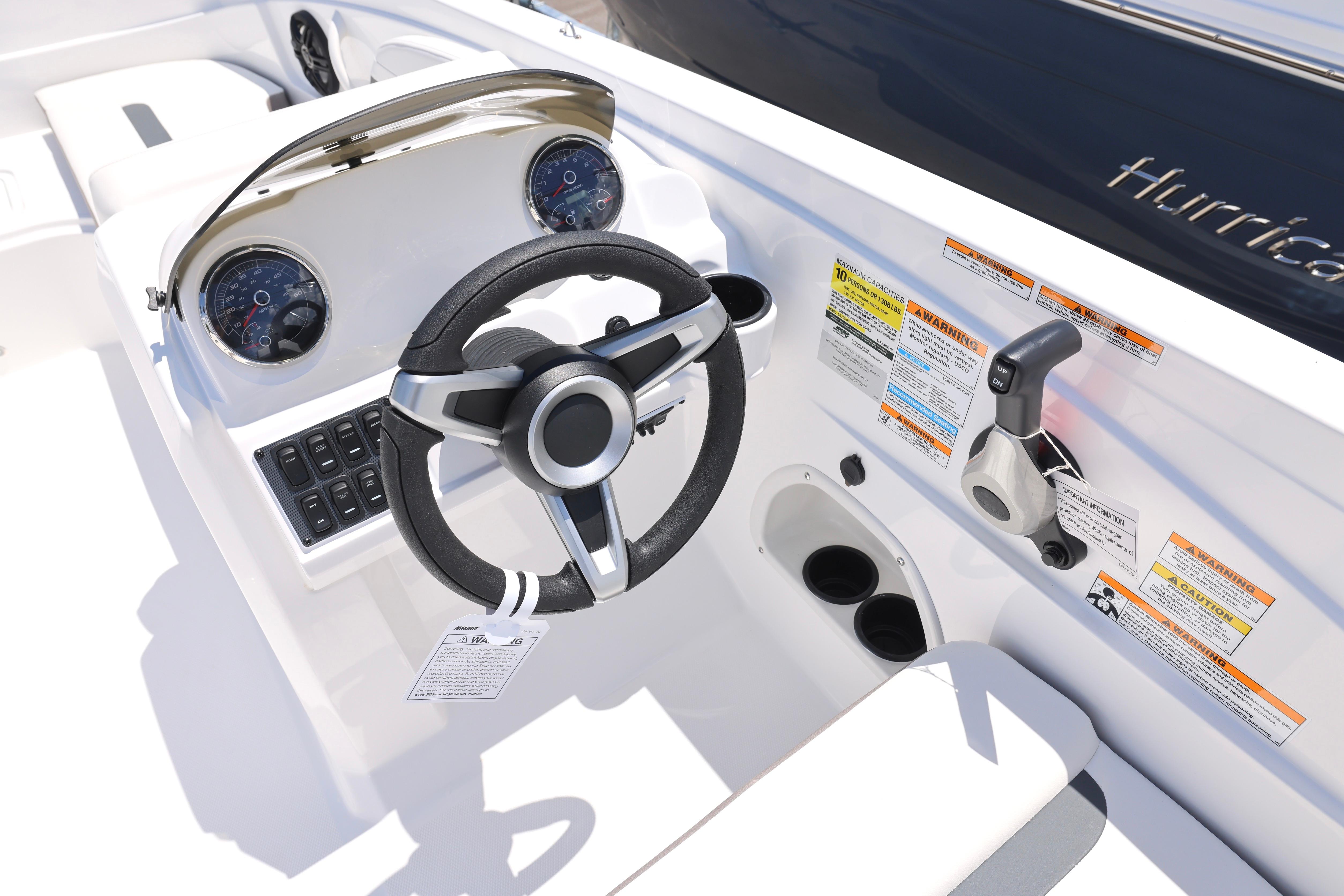 2026 Hurricane SunDeck Sport 205 OB boat dashboard with steering wheel and control panel.