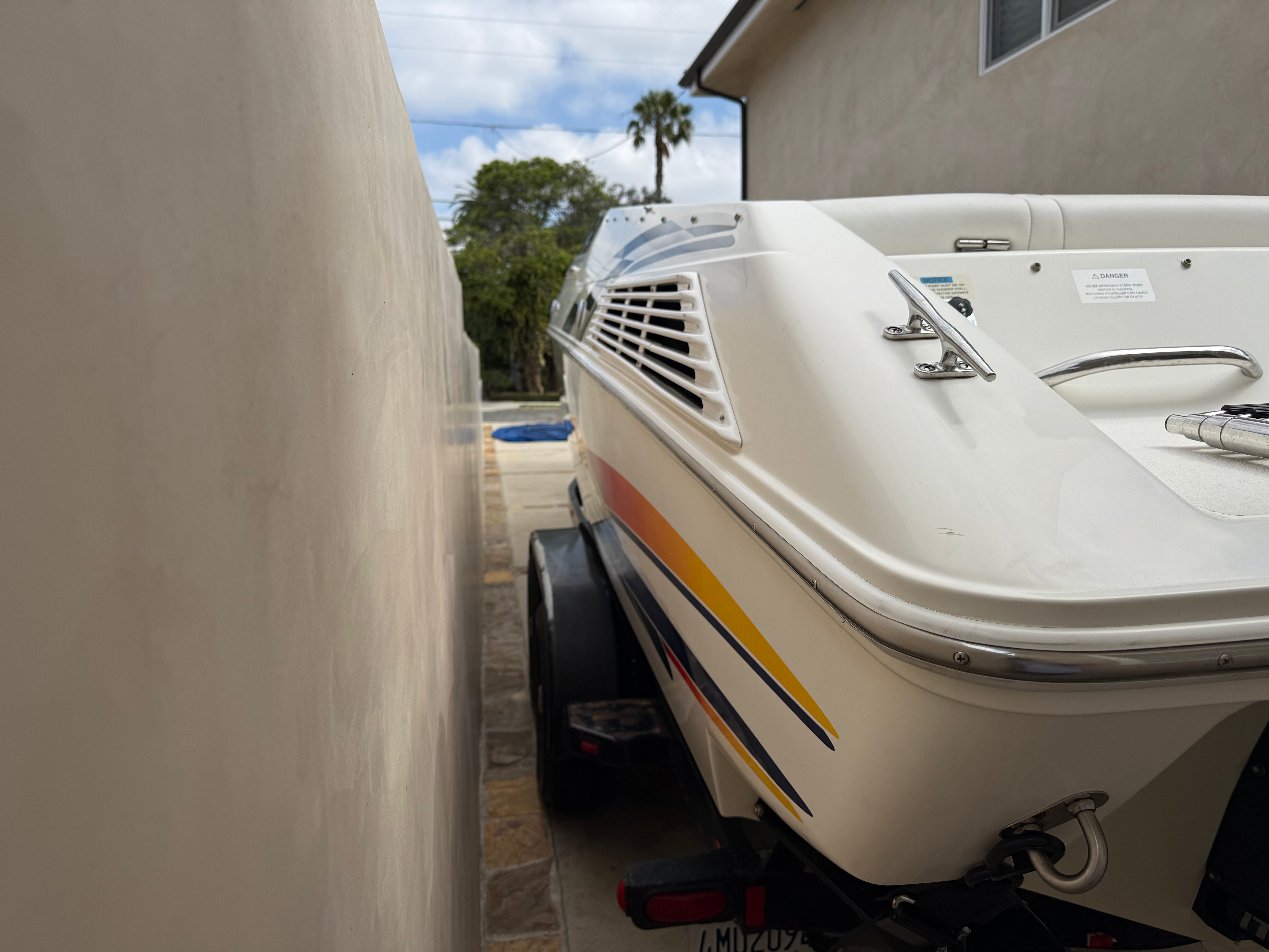 2001 Wellcraft 29 Scarab boat on trailer beside wall.