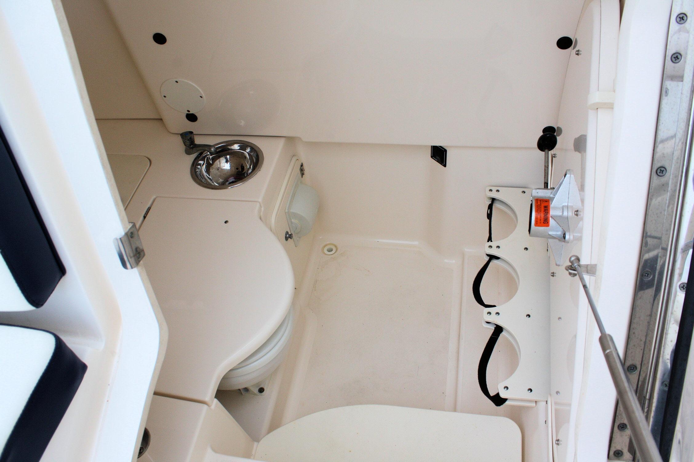 2013 Pursuit ST 310 Sport boat interior with sink and storage compartments.