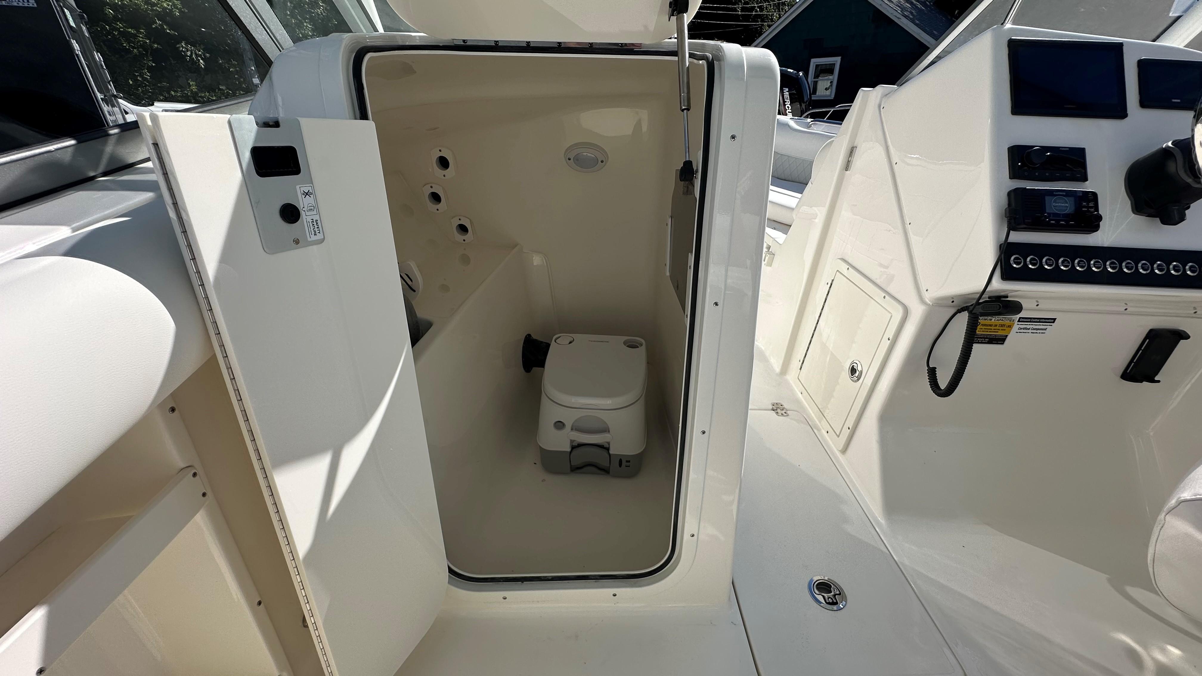 Interior view of 2026 Key West 239 DFS boat with compact marine toilet.