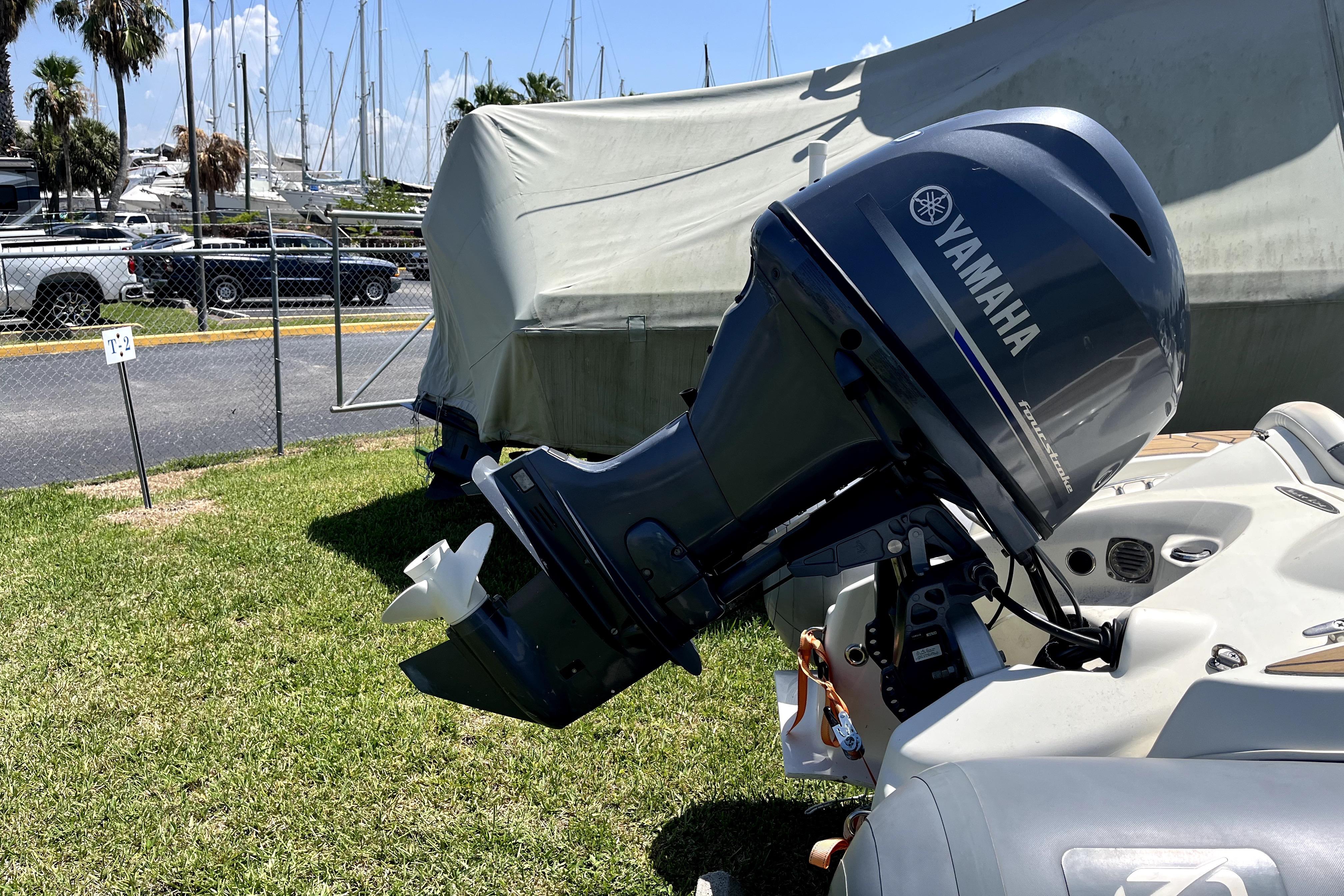 Yamaha outboard motor on a boat, parked near a marina with covered vessels.