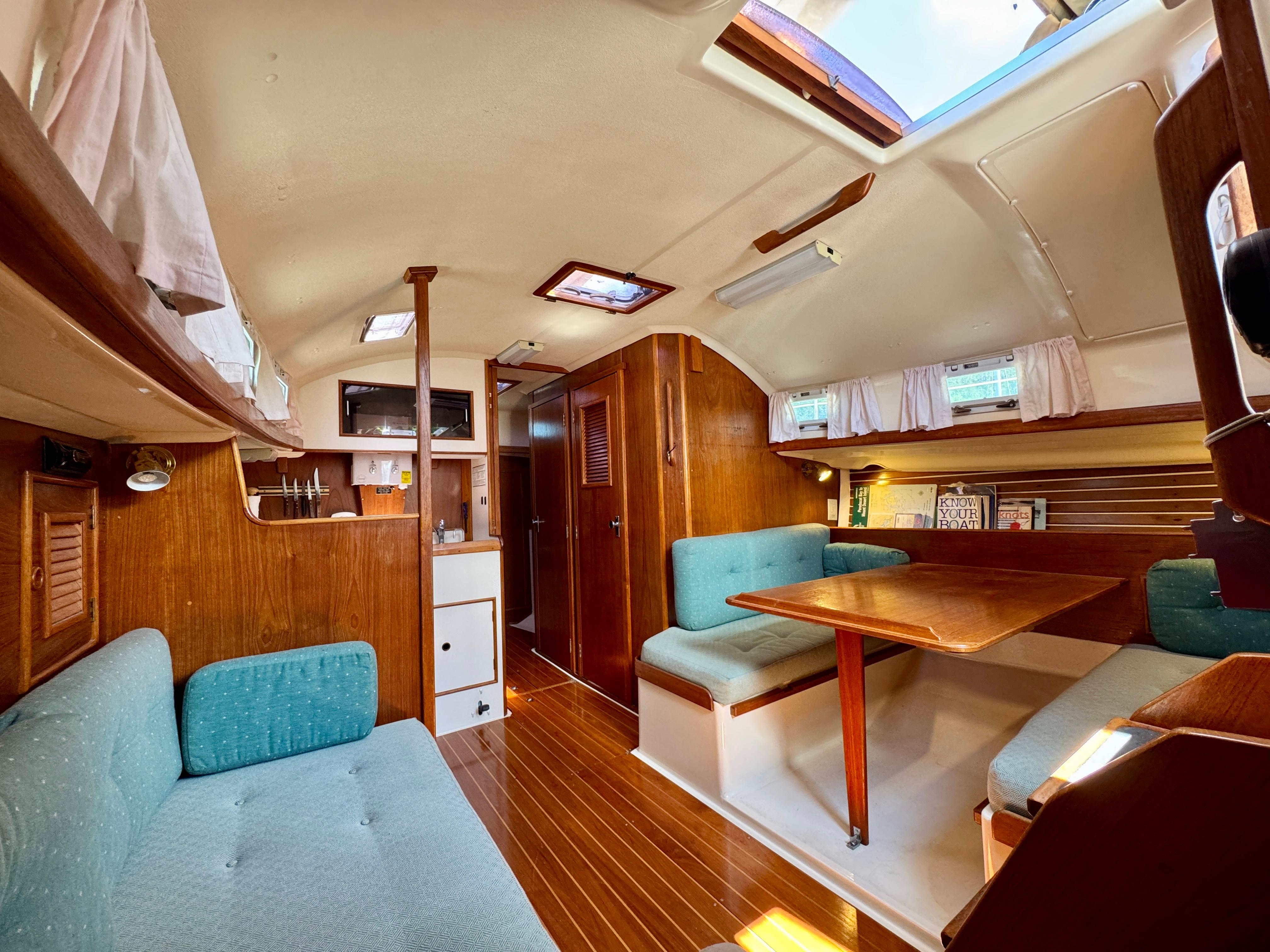 1989 Nonsuch 30 Ultra yacht interior with wood finish and teal seating.
