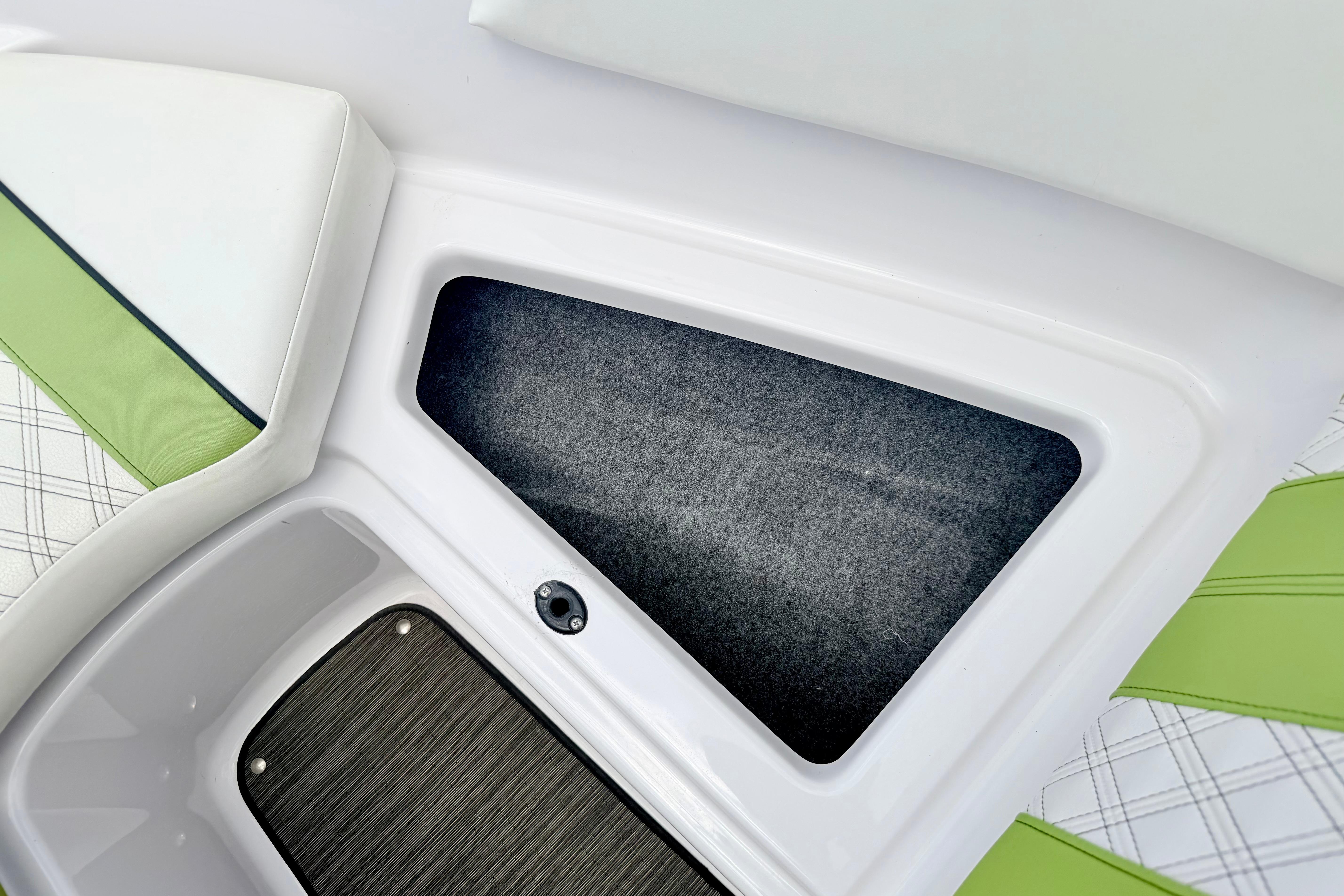 2018 Glastron GT 185 boat interior storage compartment with green and white seating.