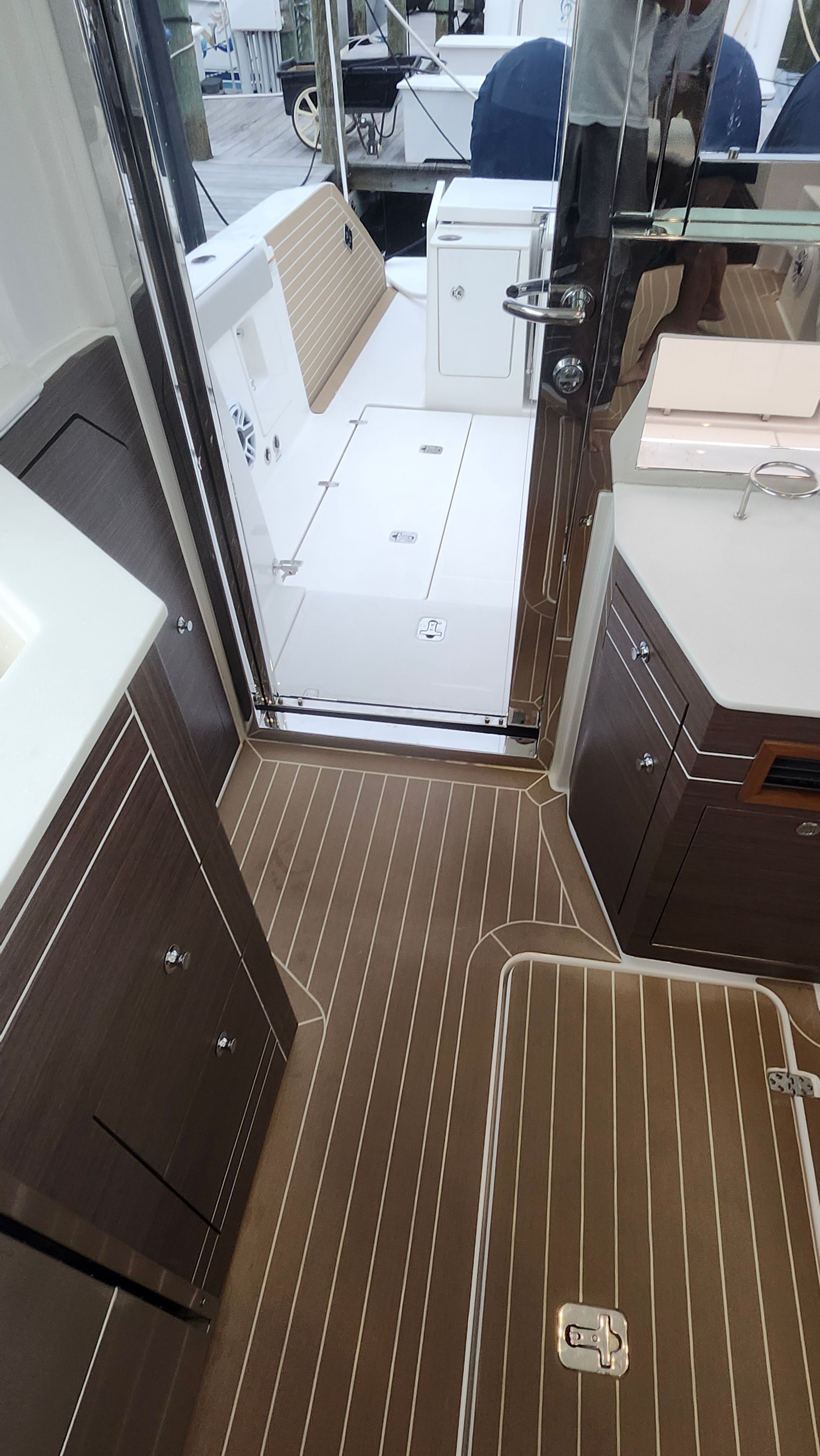 Interior of a modern yacht with wood flooring and sleek cabinets, view towards the deck.