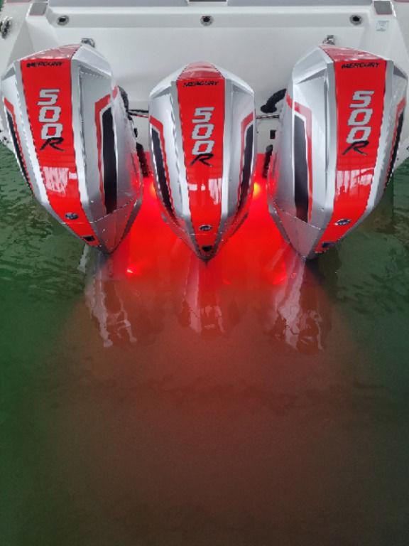 2024 Fountain 38 SCX with triple 500R engines, illuminated in red, on water.