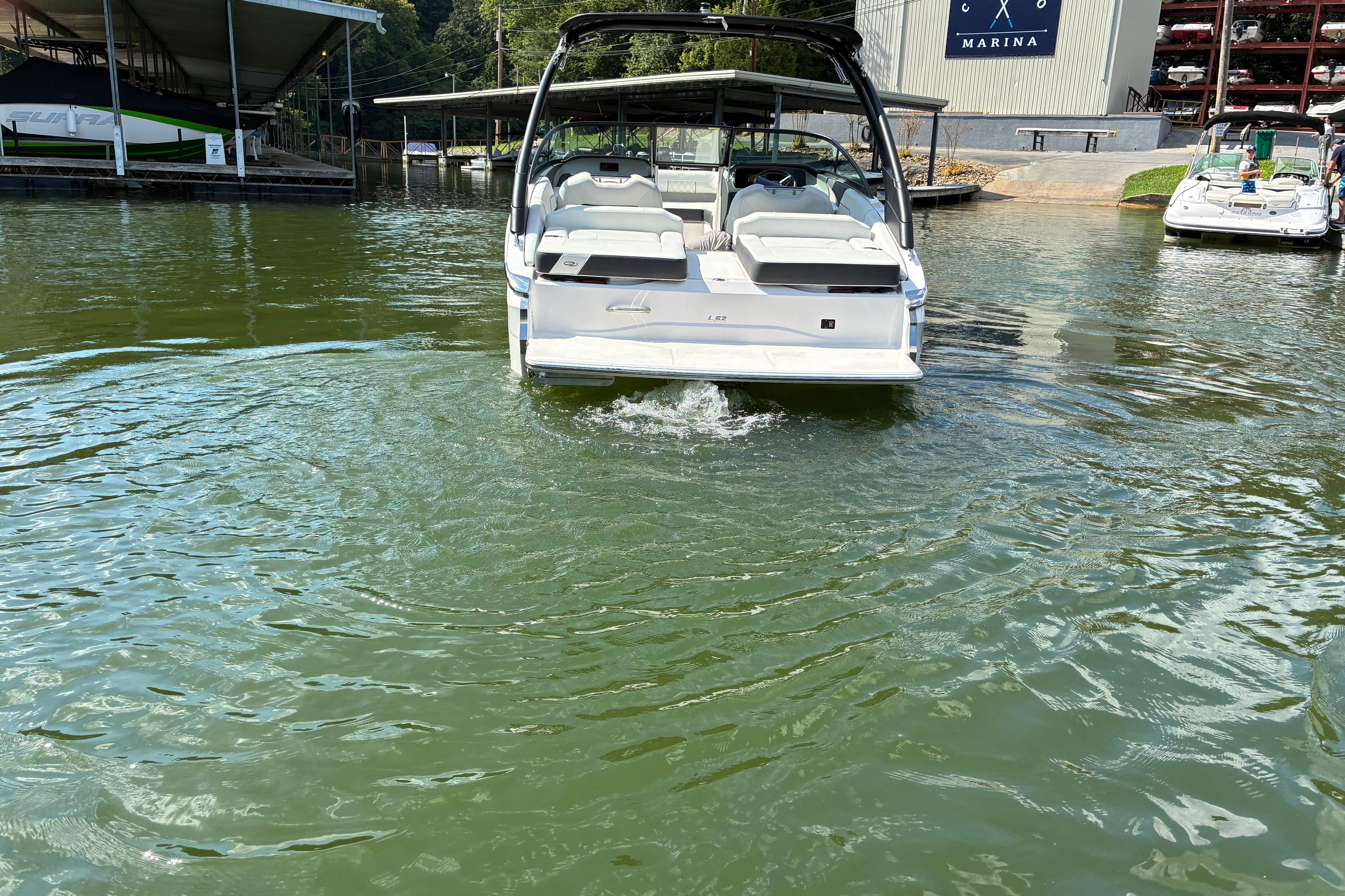 2025 Regal LS2 boat docked at marina, rear view on calm water.