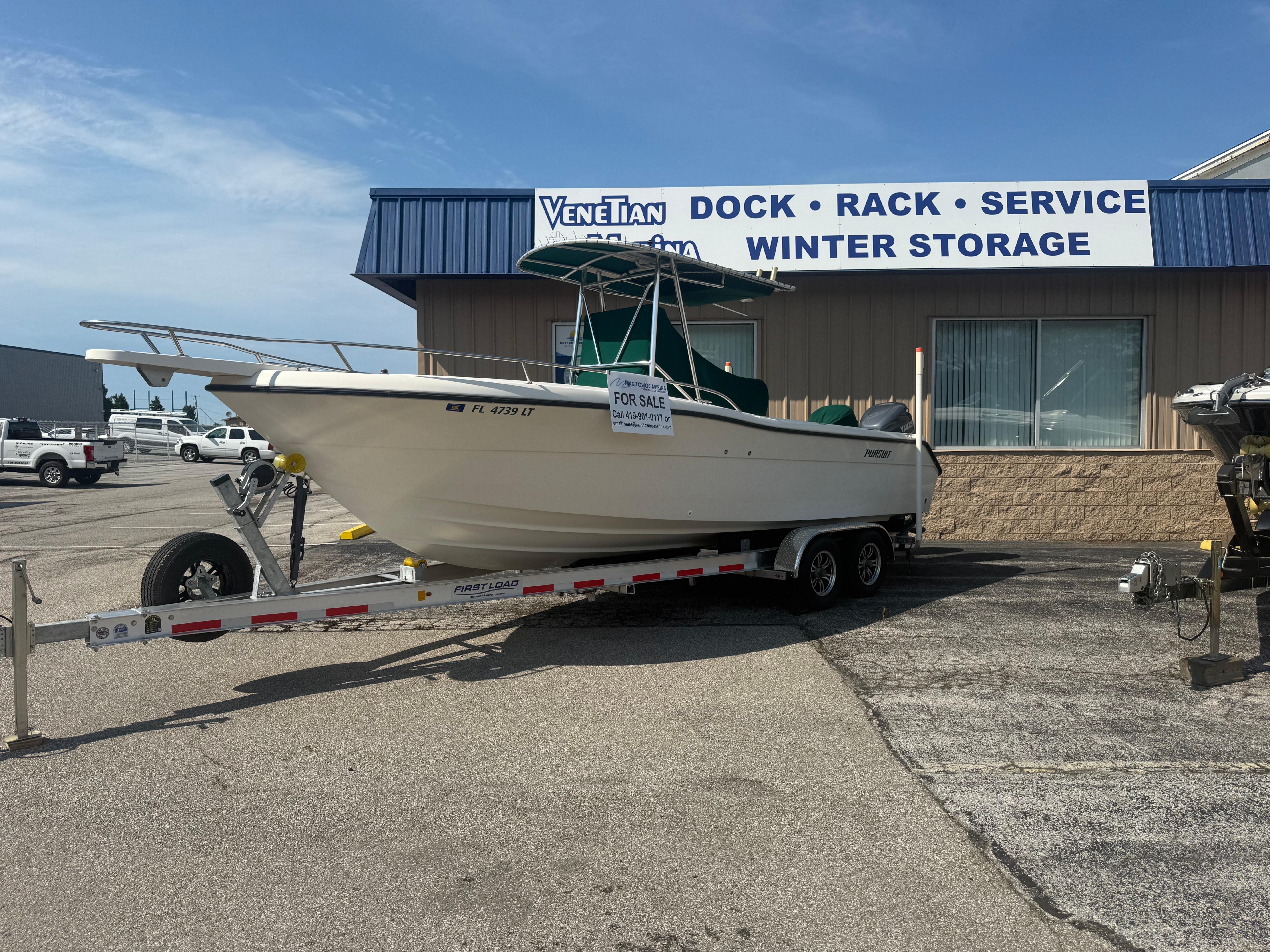 2002 Pursuit 2470 CC boat on trailer, for sale at marina service center.