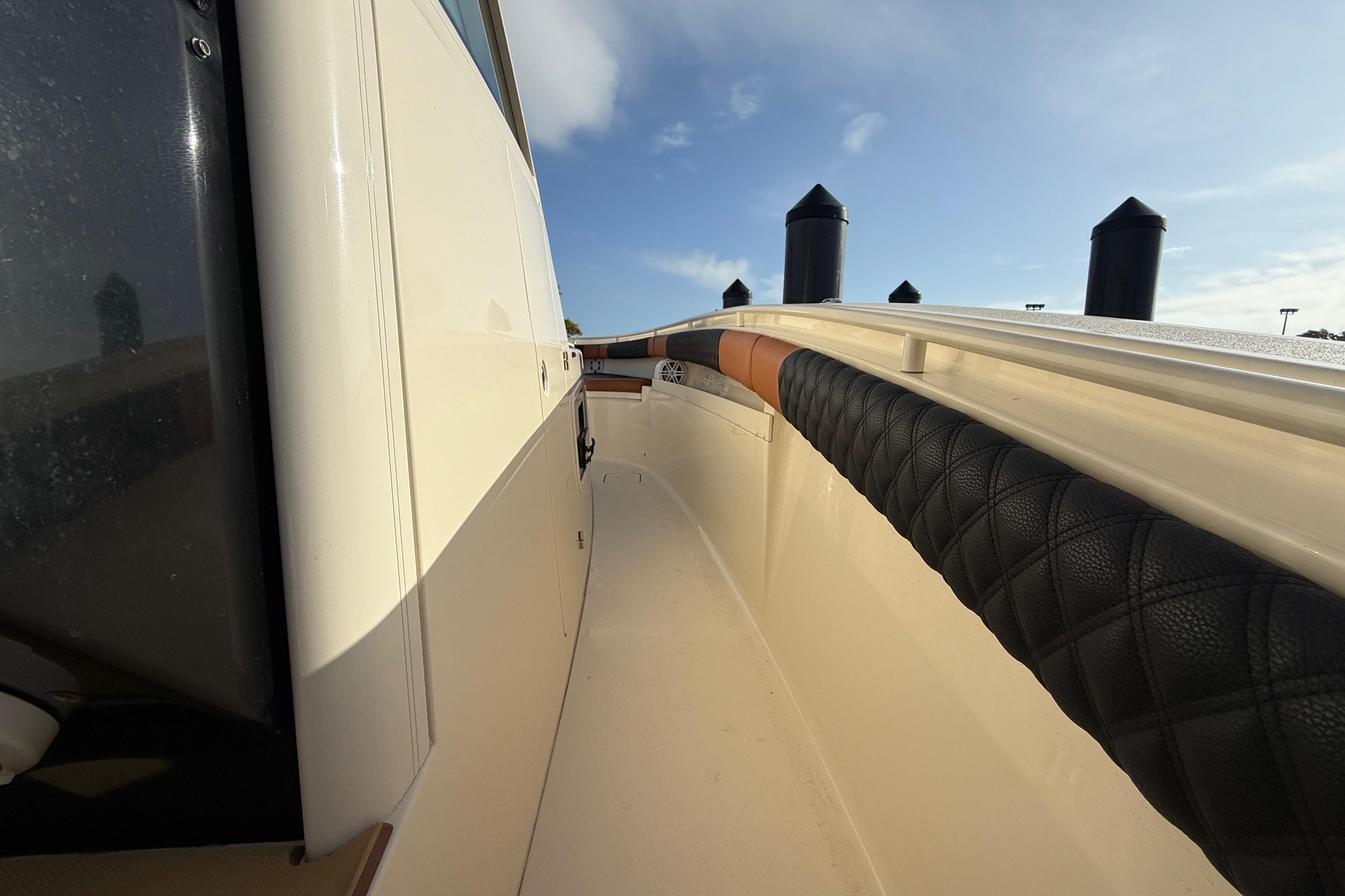 2019 Scout 355 LXF boat deck with cushioned railing under clear sky.