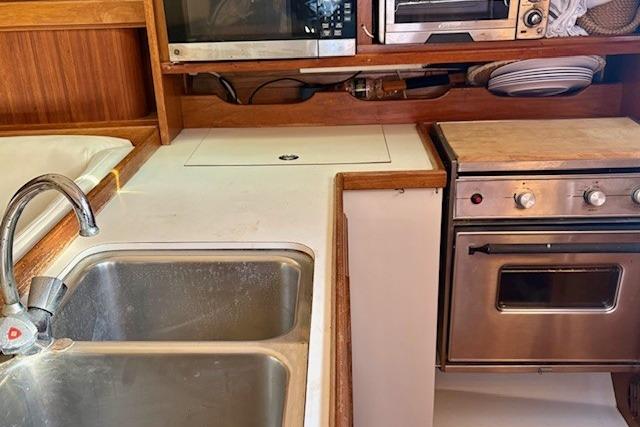 Galley kitchen in 1992 Catalina 34 sailboat with sink, stove, and microwave.
