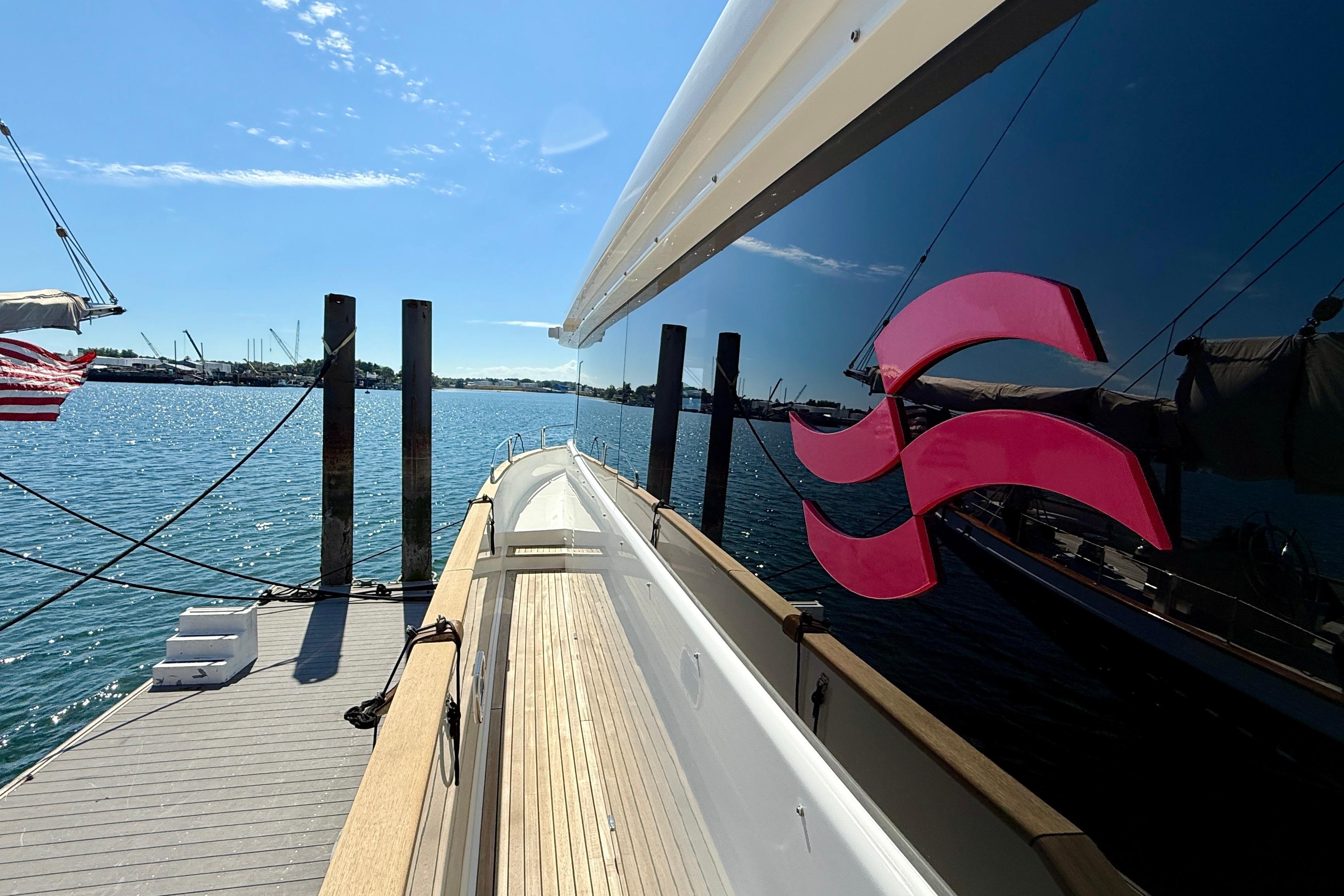 2022 Sirena 58 yacht docked, reflecting water and sky, with vibrant logo.