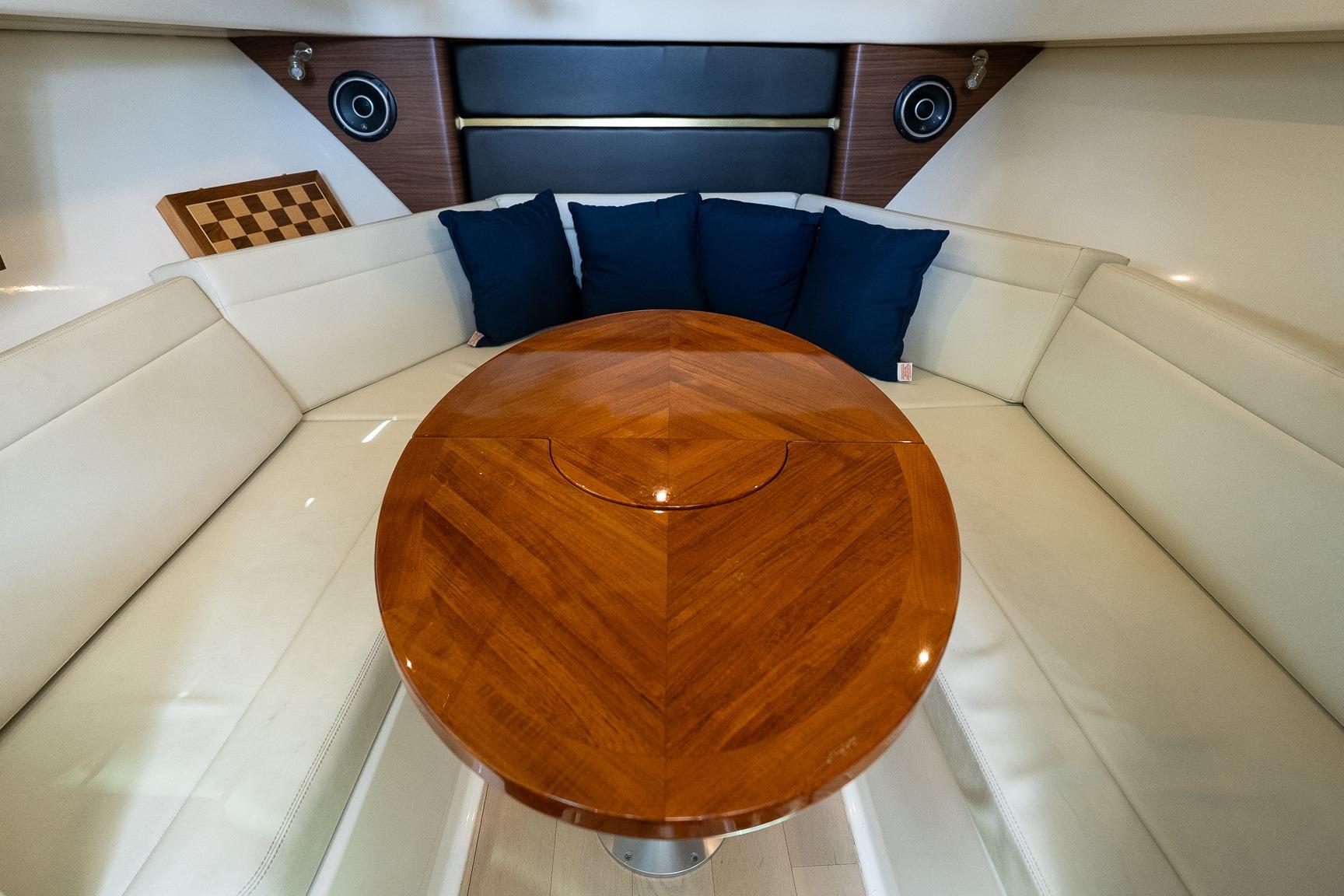 Luxurious interior of 2020 Boston Whaler 325 Conquest with wooden table and white seating.