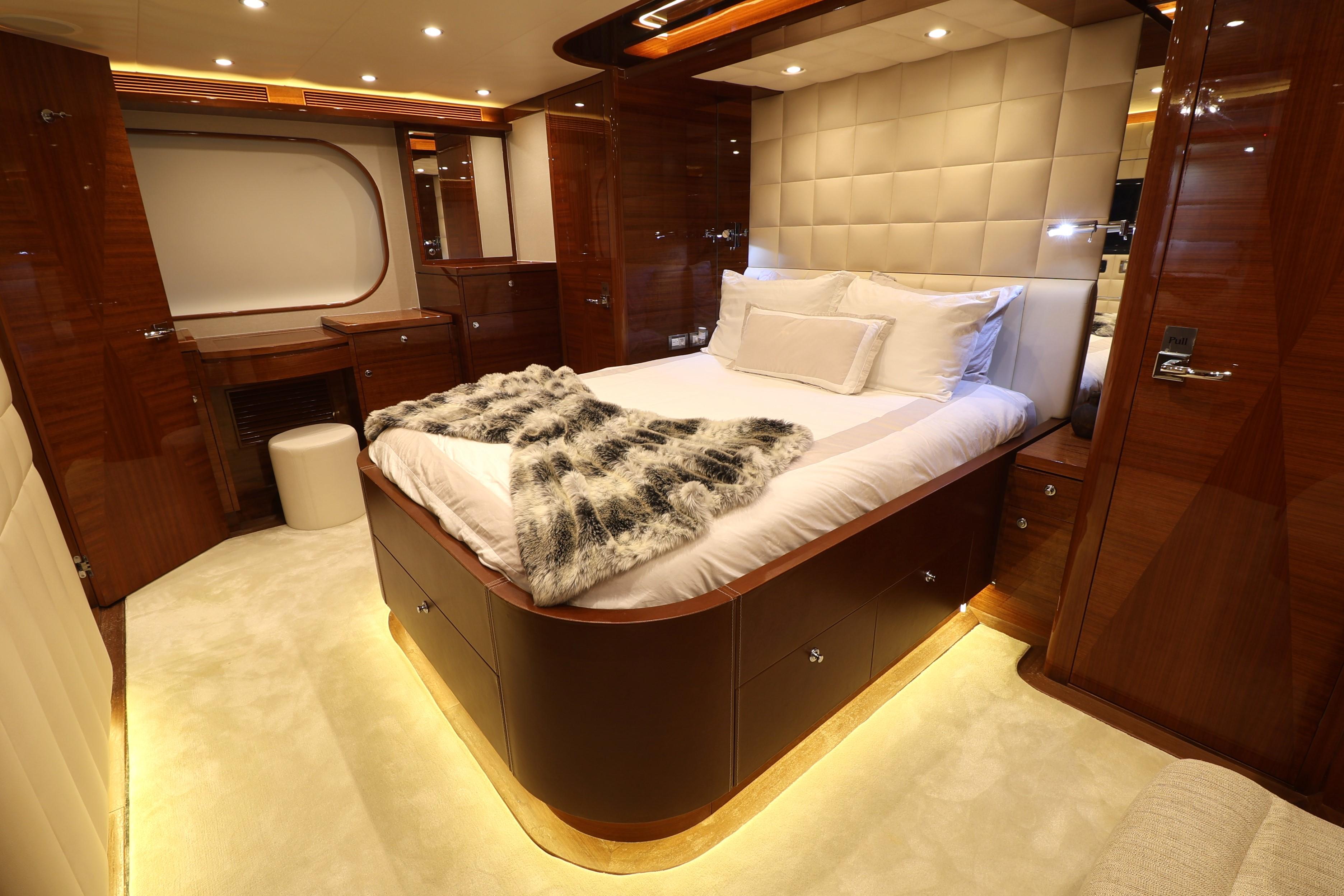 Luxurious 2013 Cheoy Lee Bravo yacht bedroom with elegant wood finishes and ambient lighting.