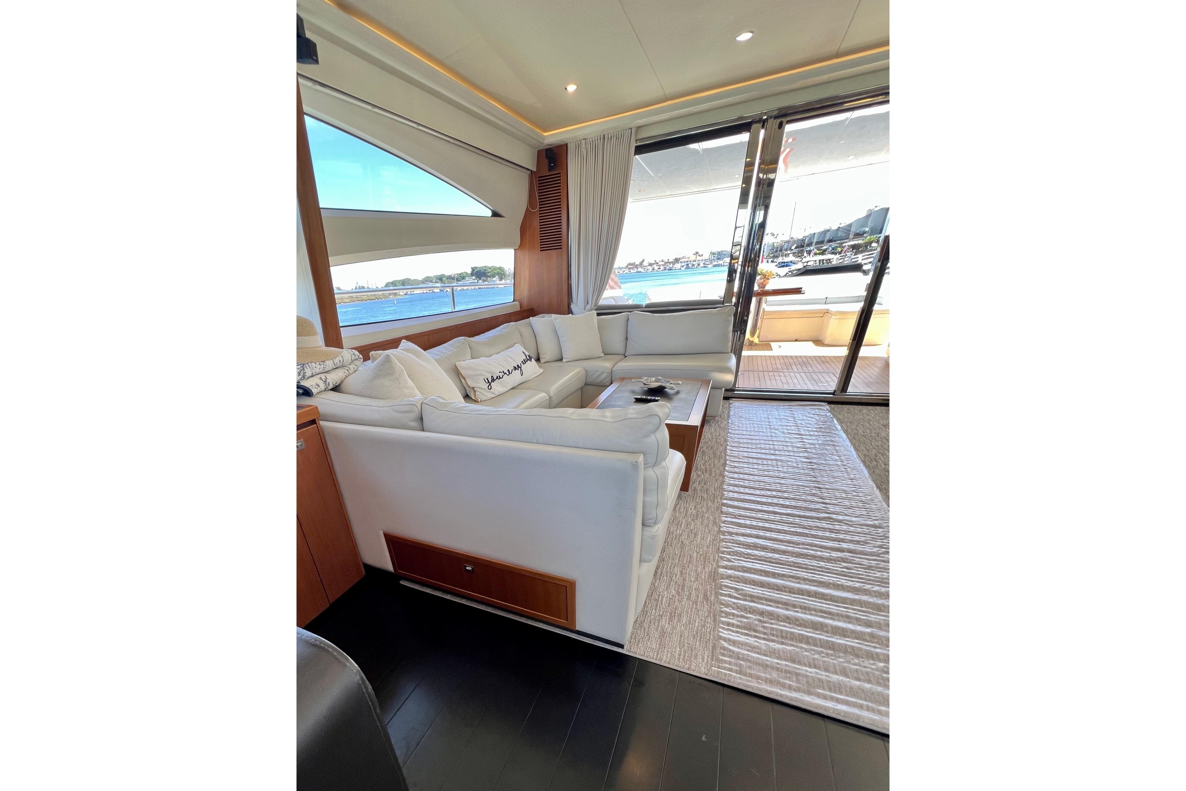 Luxurious interior of 2010 Princess V78 yacht with white seating and ocean view.