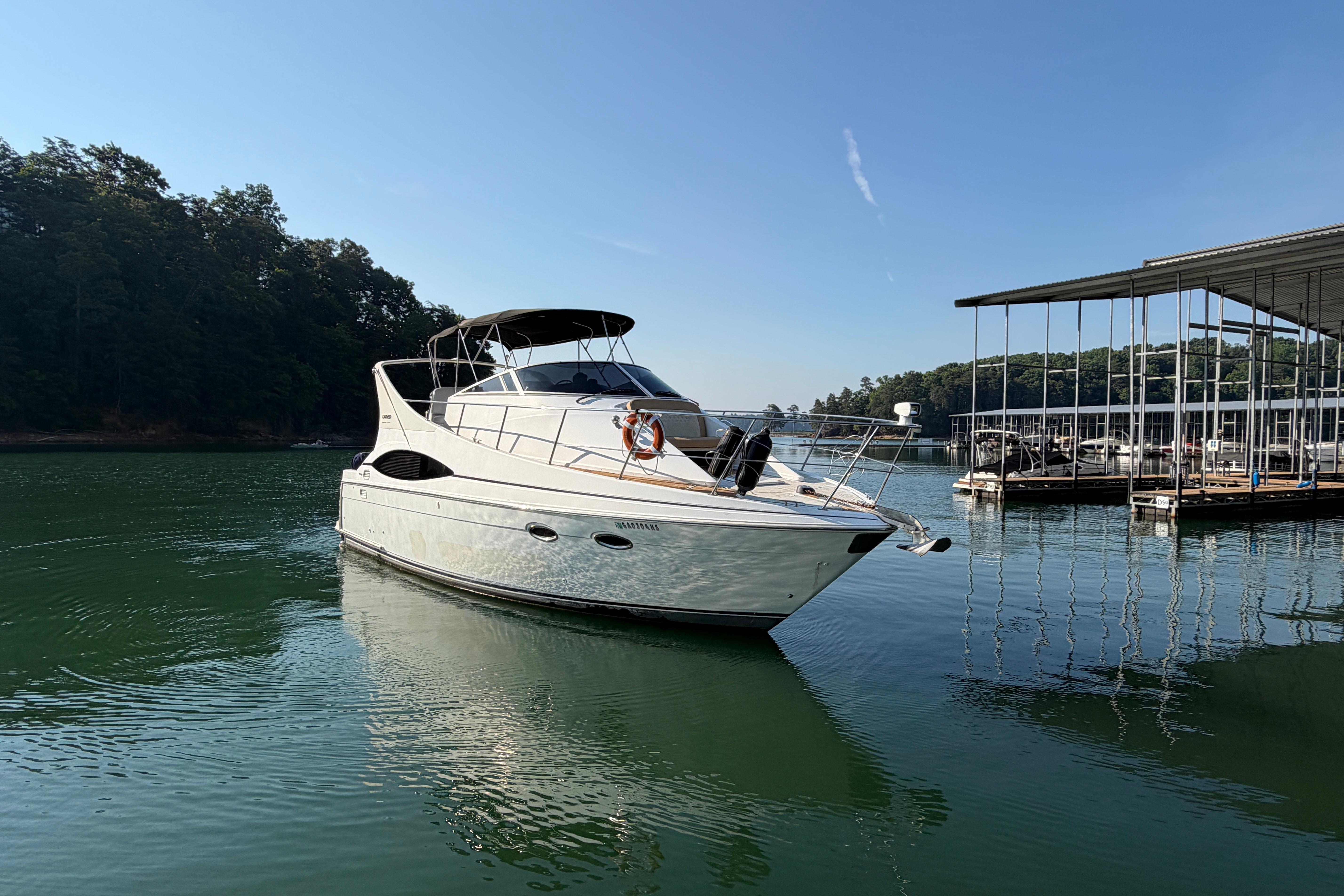 2003 Carver 350 Mariner yacht docked on calm water near a marina.