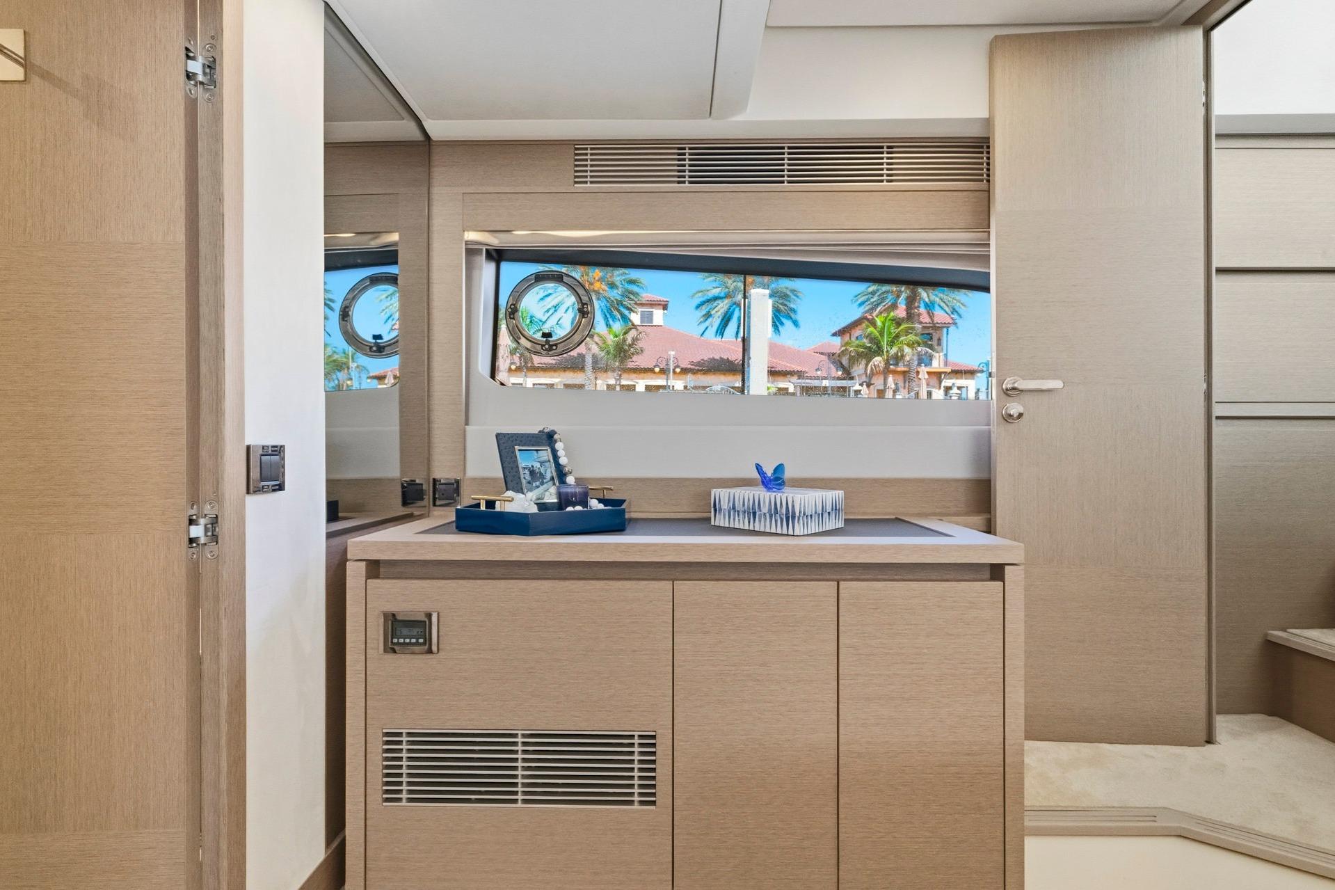 Luxurious interior of 2022 Prestige 520 yacht with elegant wood finish and scenic window view.