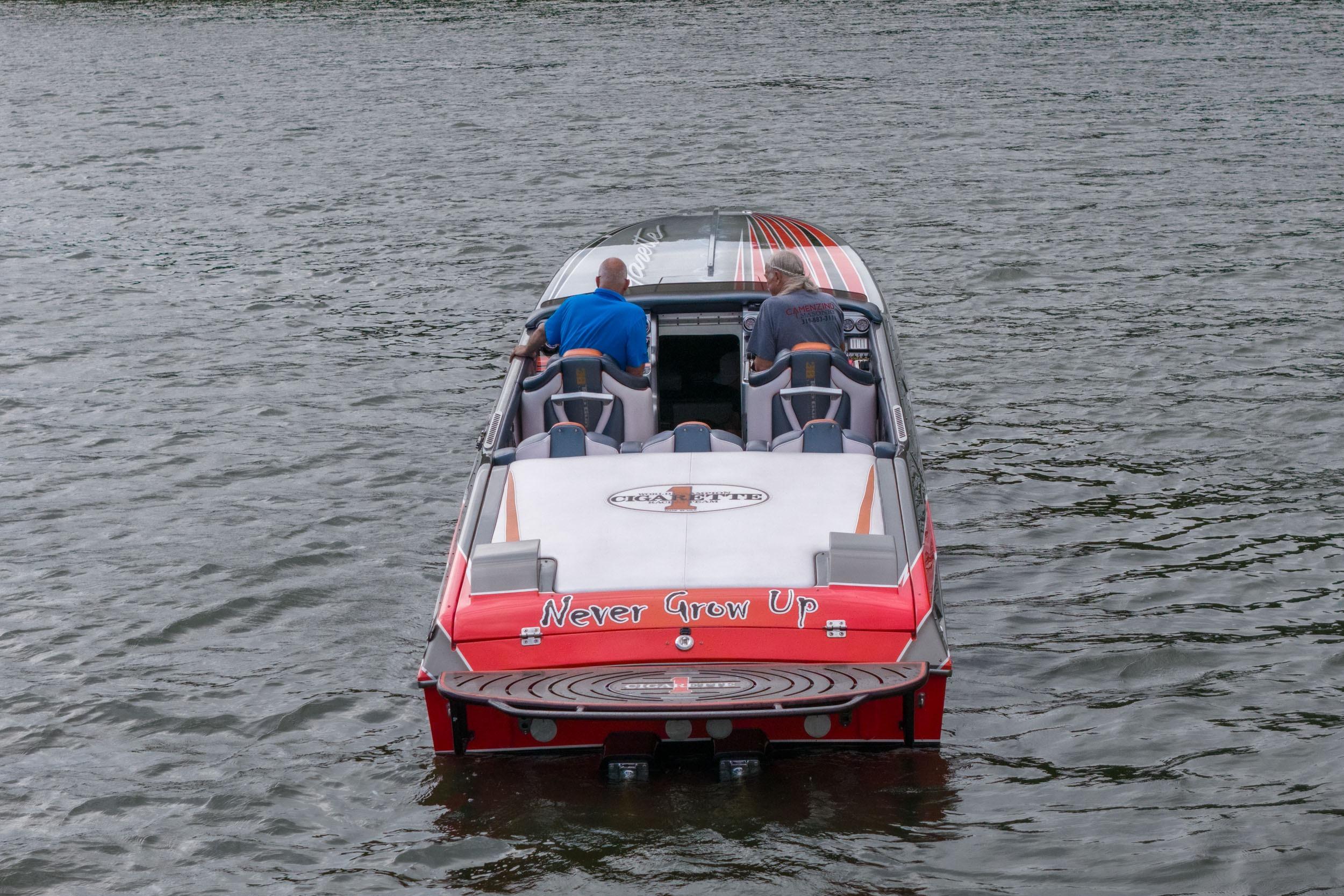 2006 Cigarette 39' Top Gun boat on water, rear view with "Never Grow Up" text.