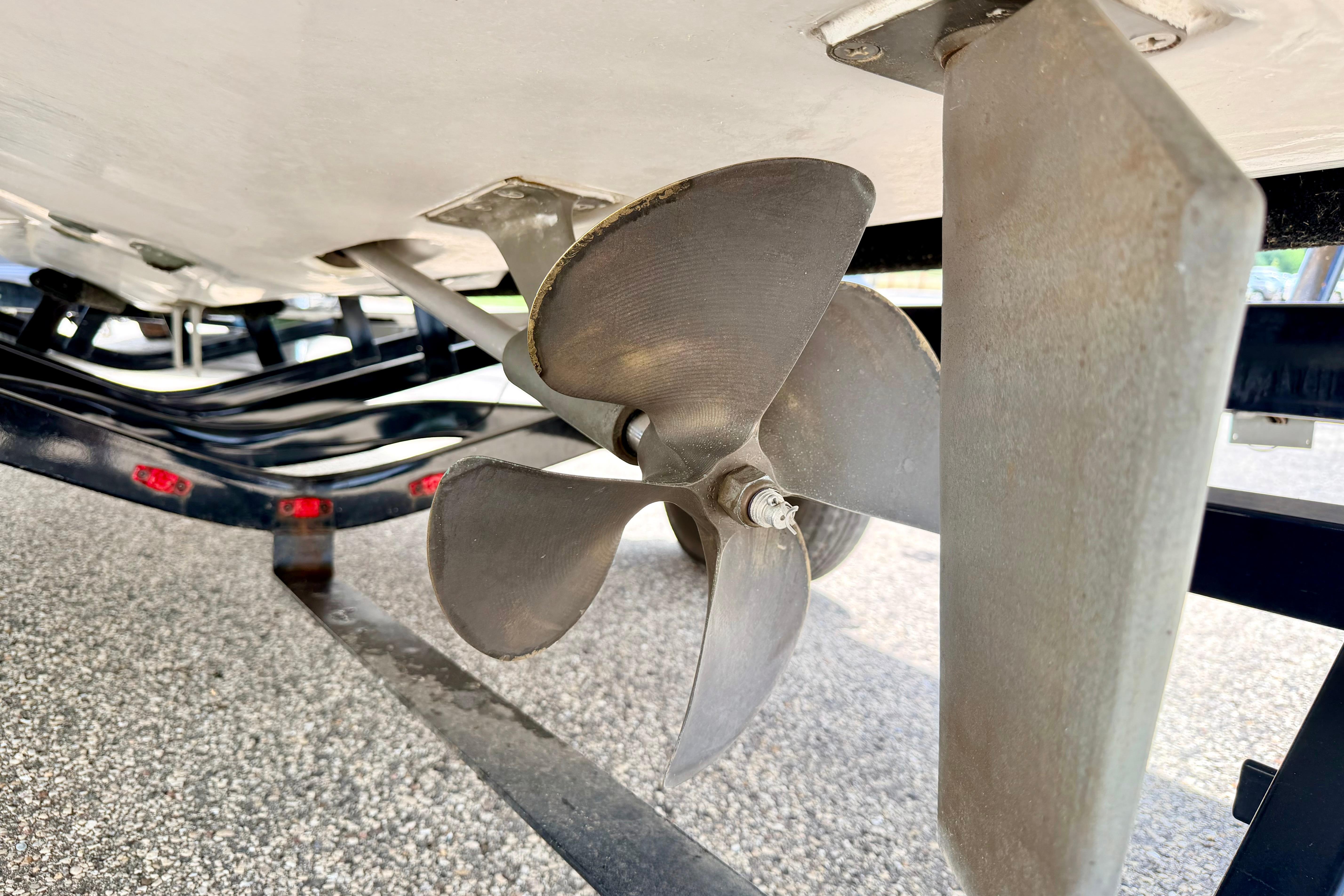 Close-up of a 2014 Tigé R20 boat propeller and rudder on a trailer.