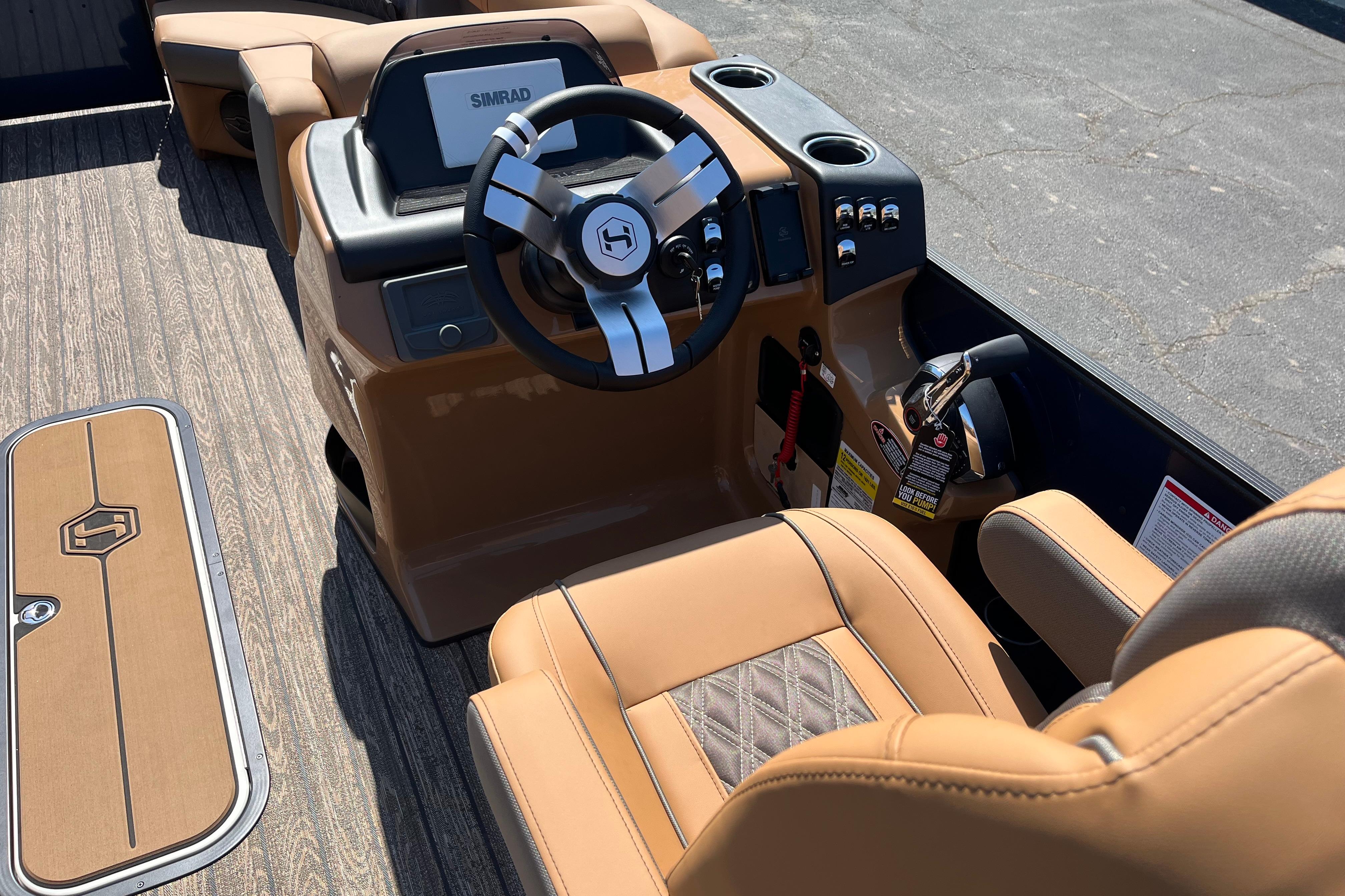 2026 Harris Cruiser 230 SL boat interior with tan leather seating and modern steering console.
