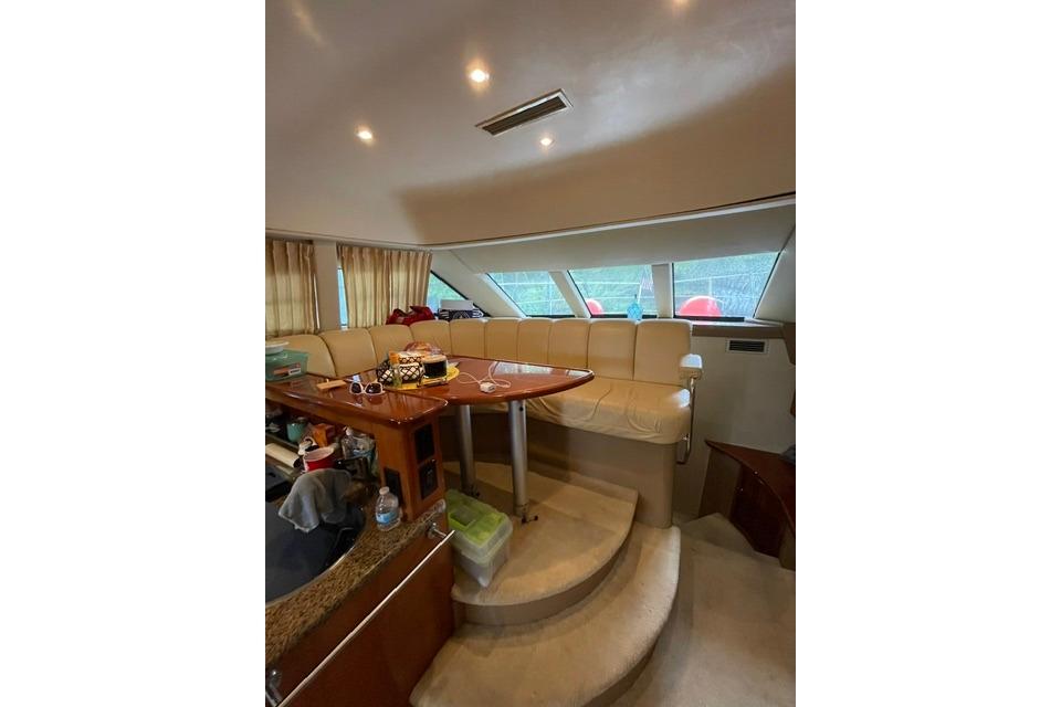 Interior of 2003 Carver 36 Super Sport yacht with plush seating and wooden table.
