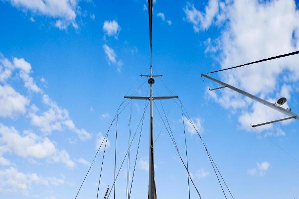 Sailboat mast against blue sky with clouds, Concordia 52, 1989 model.