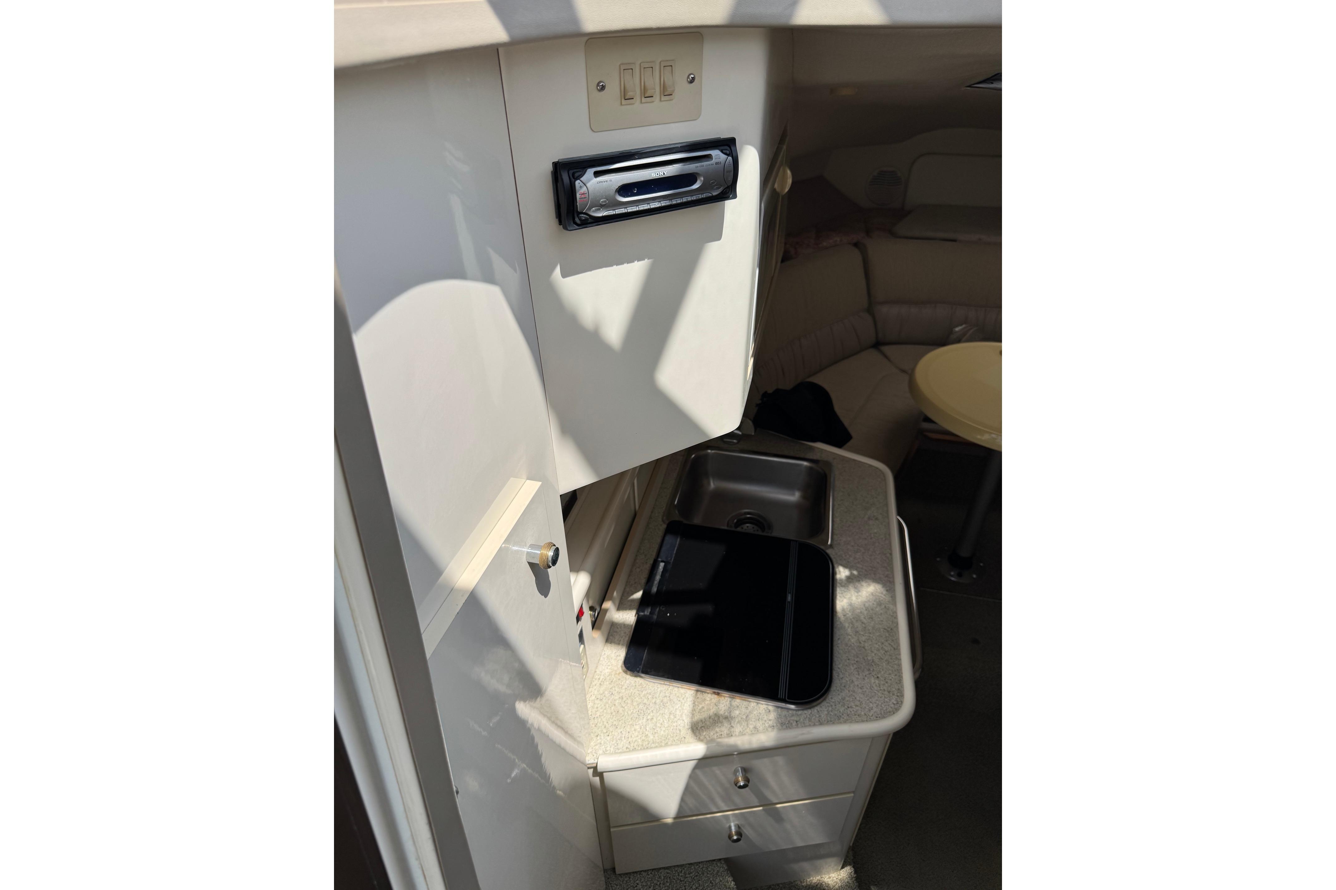 Interior of 2000 Maxum 2400 SCR boat showing kitchenette with sink and seating area.
