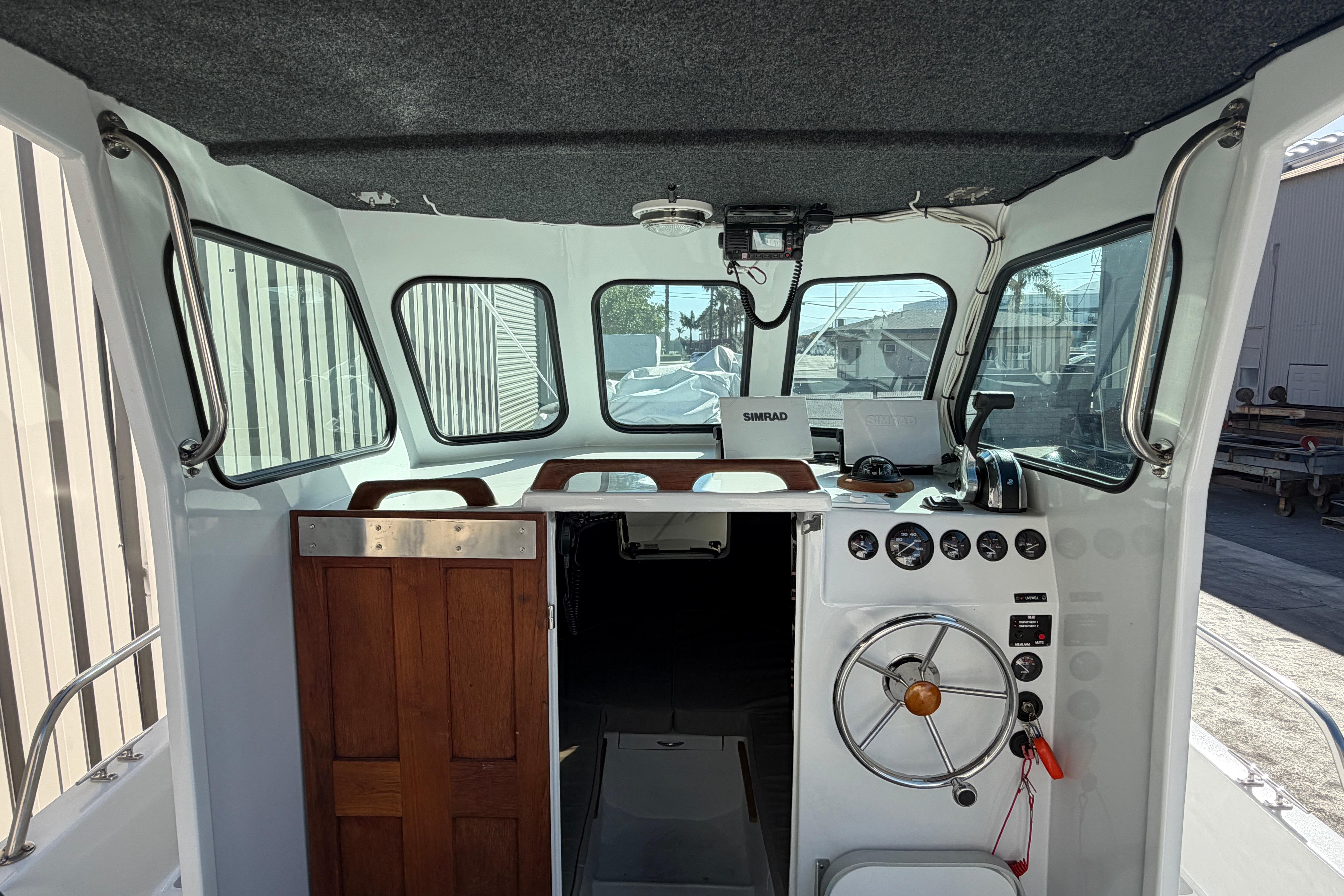 Interior of a 1986 Radon 21 Sport boat with steering wheel and control panel.