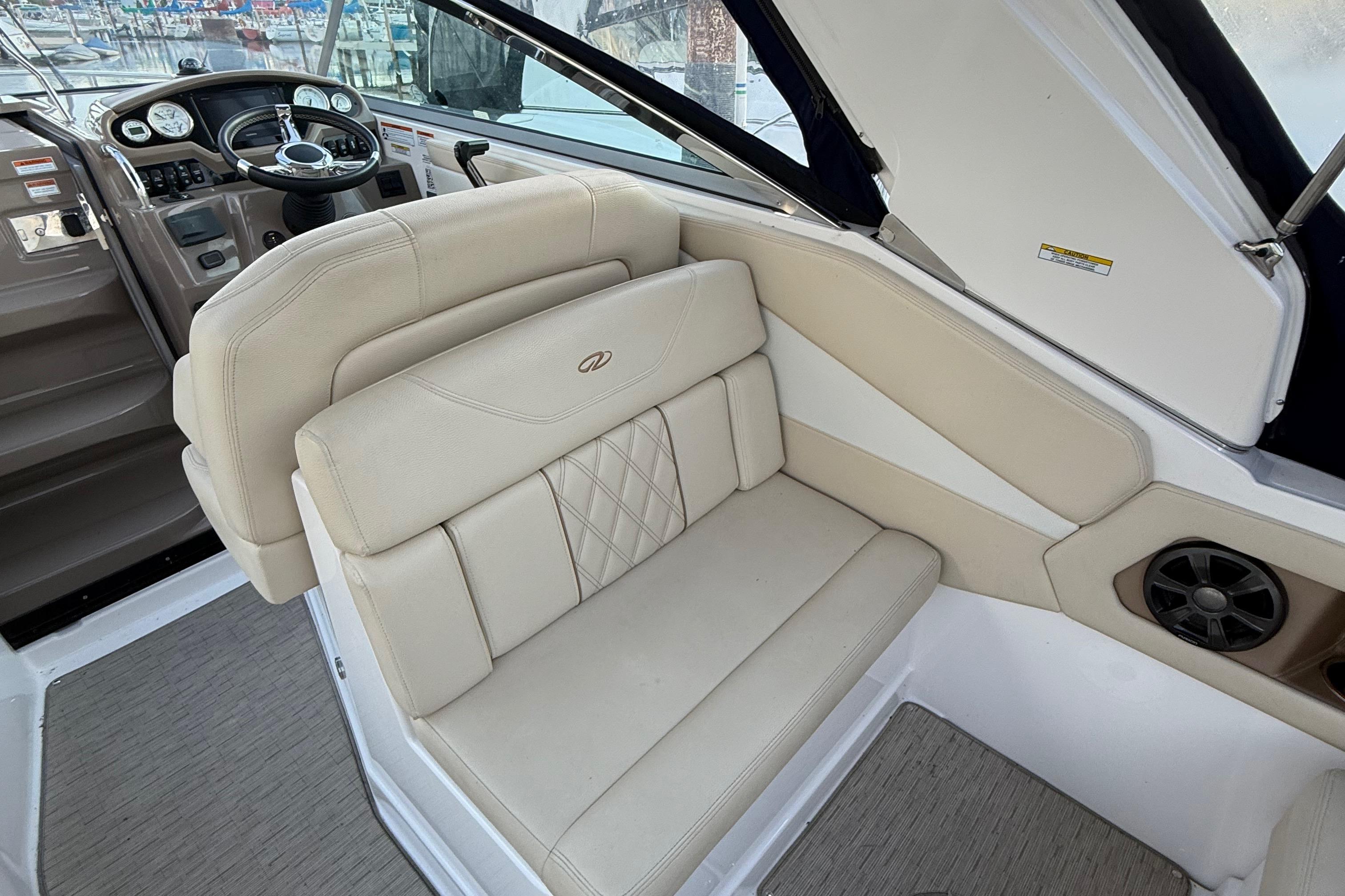 2018 Regal 28 Express boat interior with beige seating and steering console.