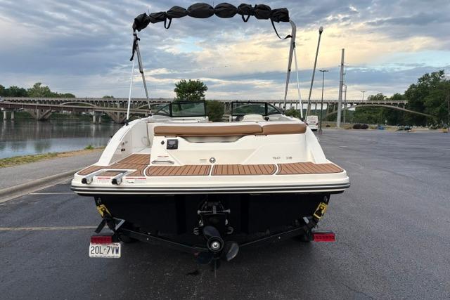 2017 Searay SPX210 boat on trailer, parked near a river with a scenic bridge view.