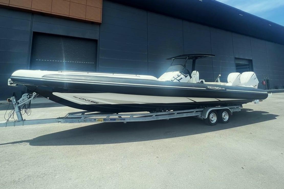 2021 Technohull Sea DNA 999 boat on trailer, parked outdoors.