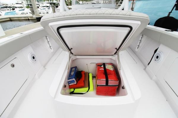 Open storage compartment on 2024 Jupiter 34 HFS boat with safety gear inside.