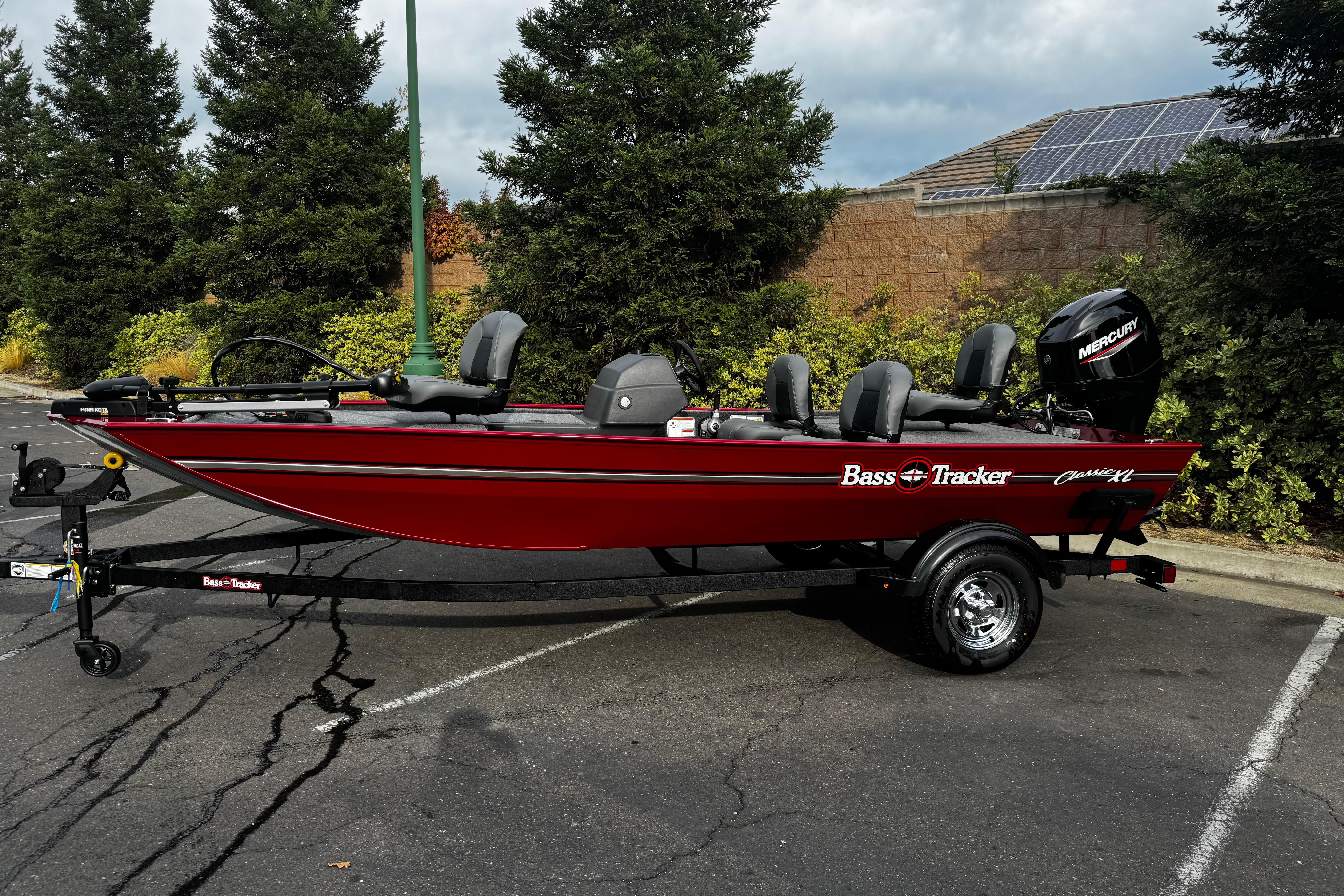 2026 Tracker Bass Tracker Classic XL boat in parking lot, red with Mercury engine.