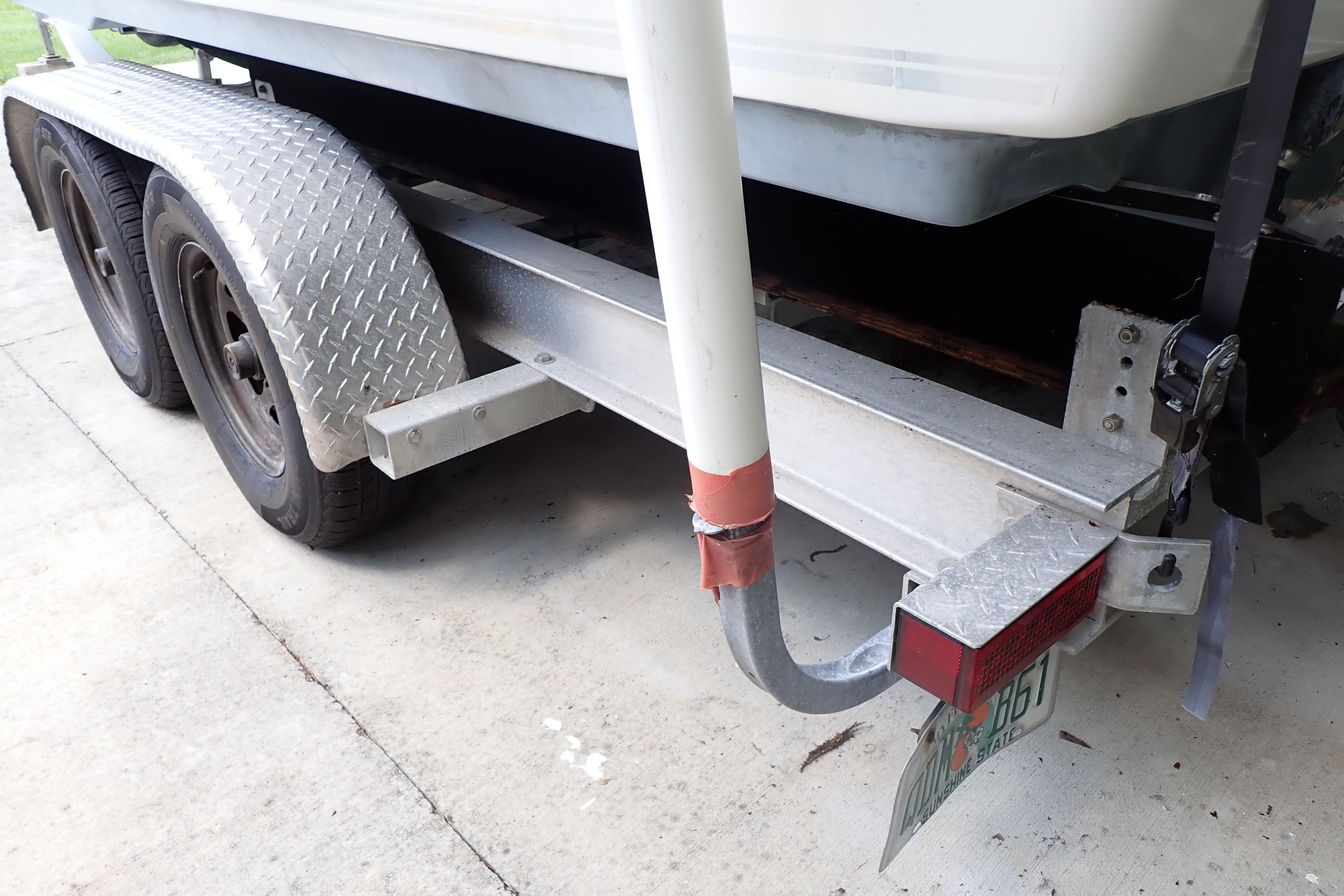 Trailer for 2019 Key West 263 FS boat, featuring dual axles and diamond plate fenders.