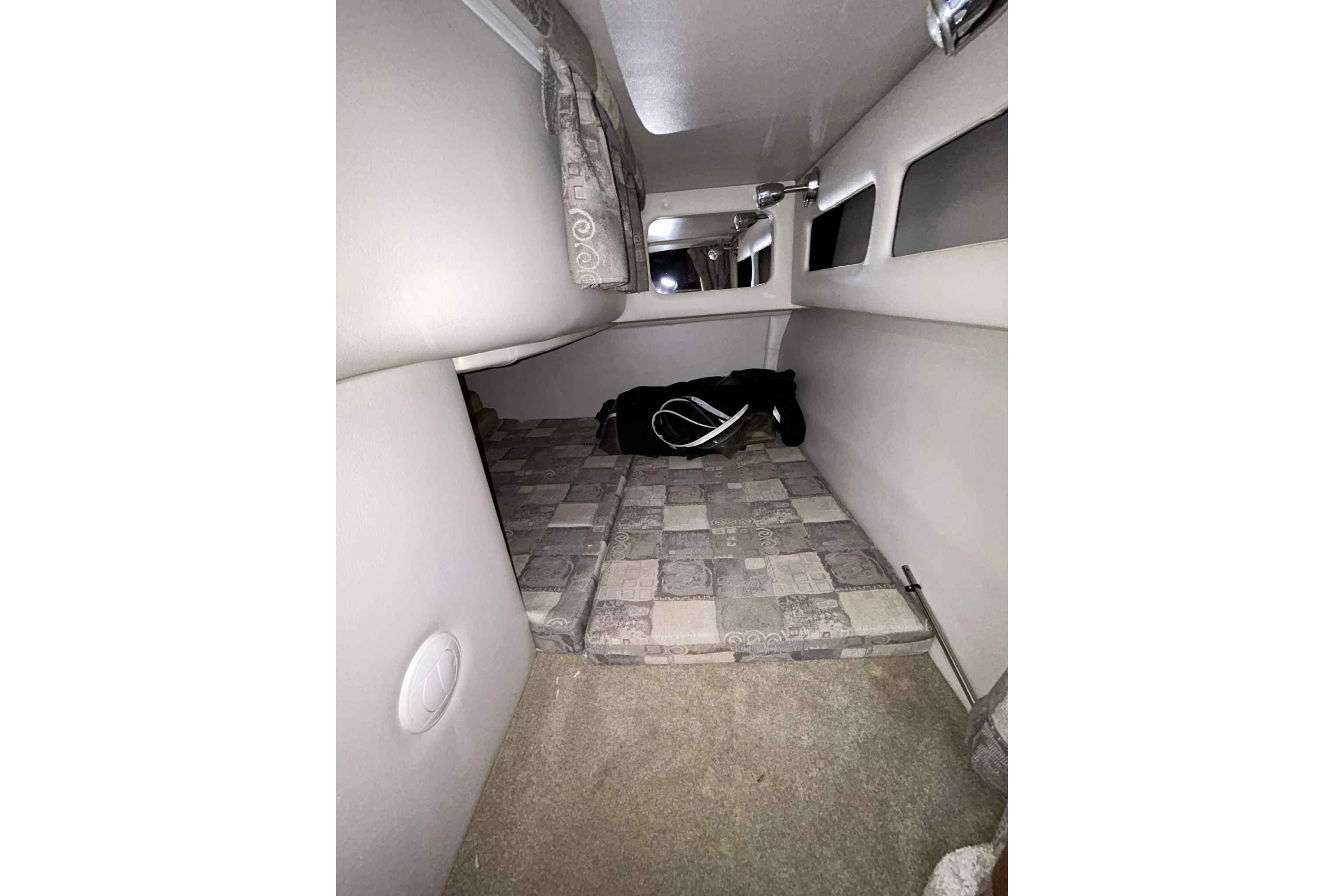 Interior cabin of 2011 Crownline 280 CR boat with cushioned sleeping area.