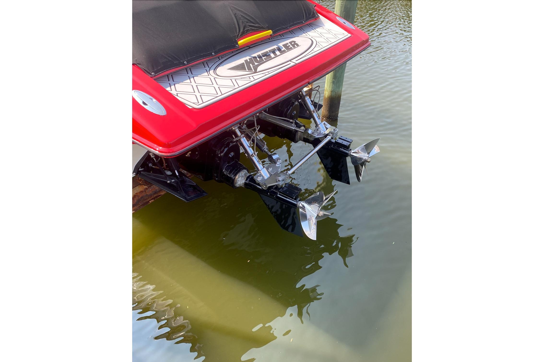 Rear view of a 2005 Hustler 388 SLINGSHOT boat with dual propellers in water.