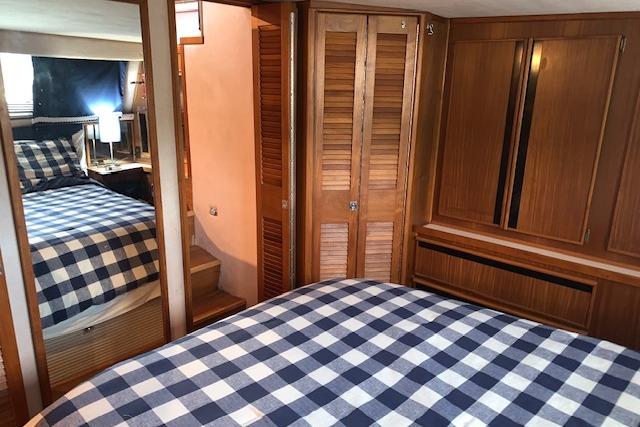 1987 Sea Ray 410 Aft Cabin interior with checkered bedding and wooden cabinetry.
