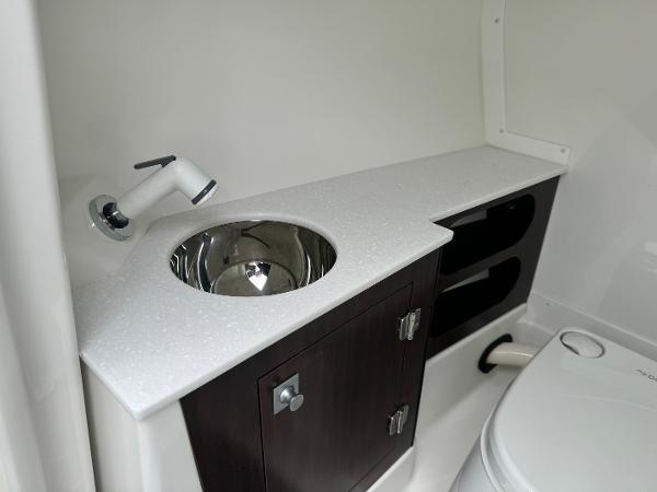2018 Monterey 258 Super Sport boat bathroom with sink, faucet, and storage cabinet.