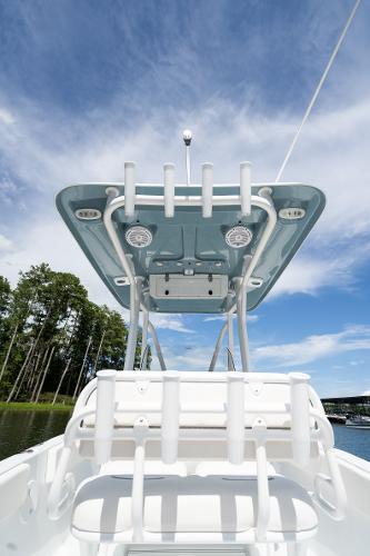 2024 Sea Hunt Ultra 234 boat with rod holders and canopy on a sunny day.