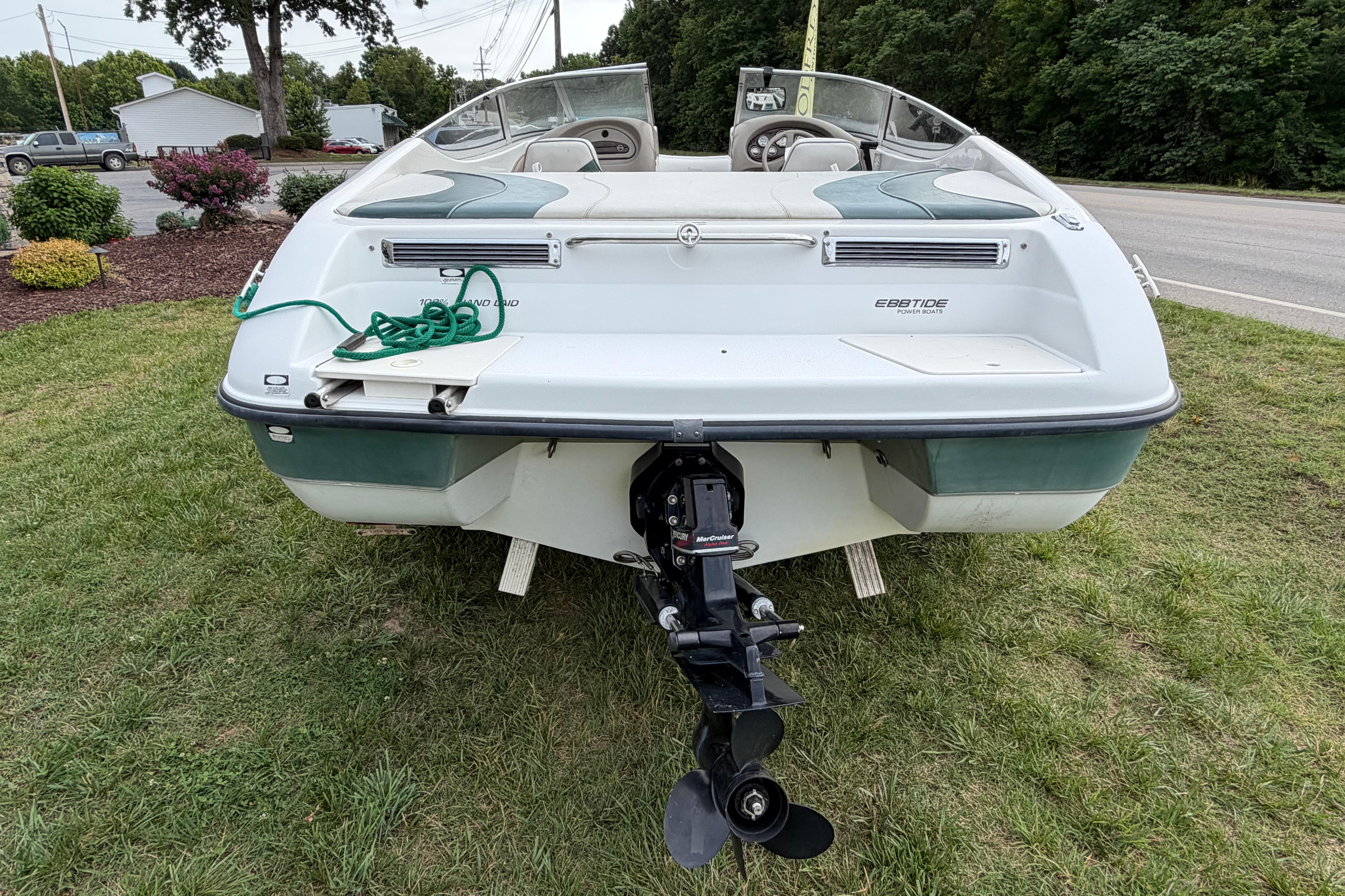 2001 Ebbtide Campione 190 boat rear view with outboard motor on grass.