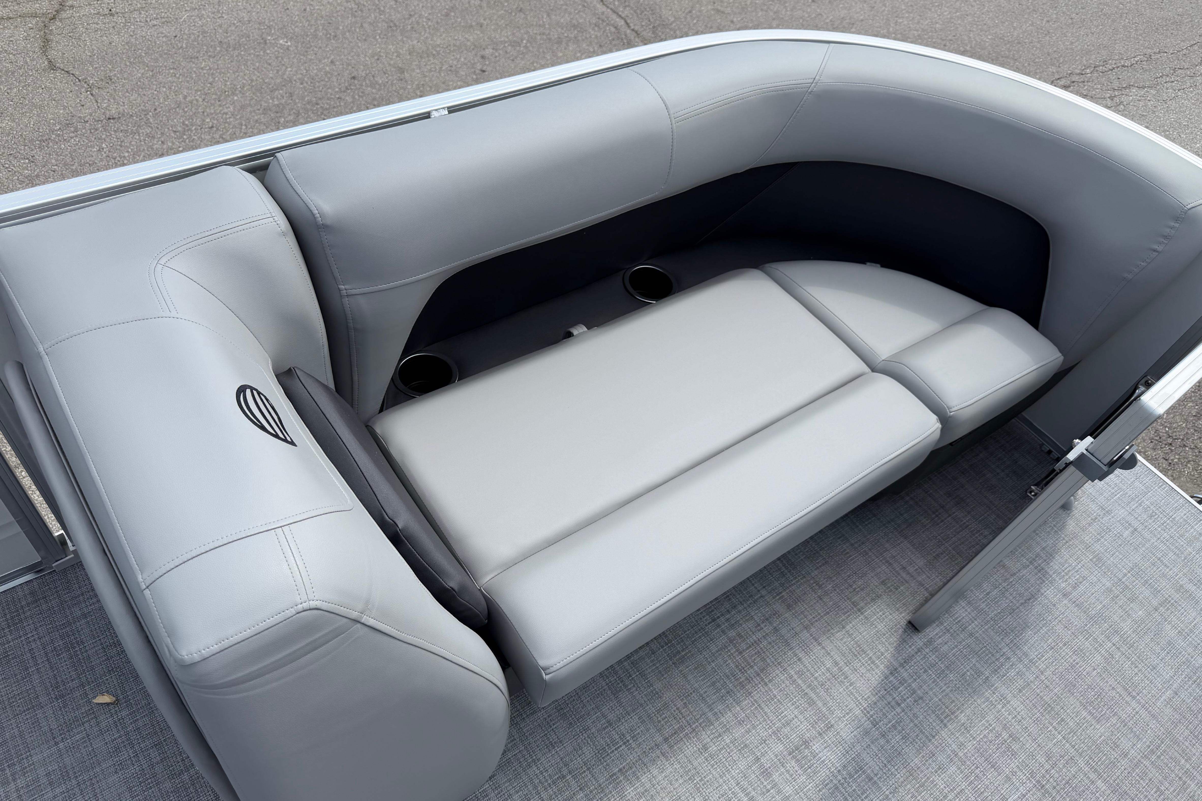 2026 Sun Tracker Party Barge 18 DLX interior with plush gray seating and cup holders.