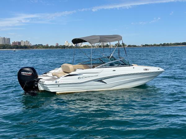 2023 Crownline 215 XS boat on water with Mercury outboard motor.