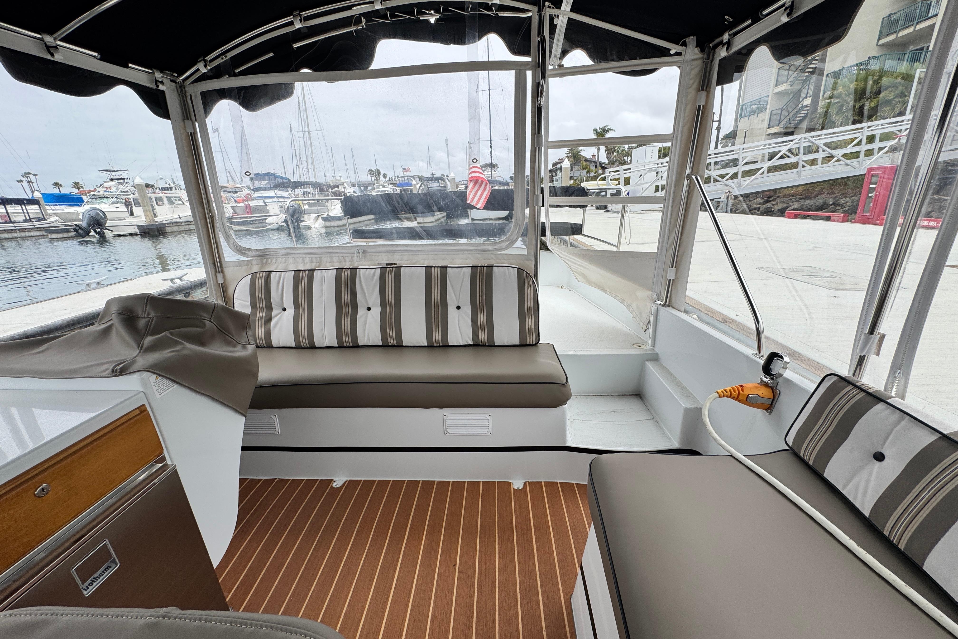 2023 Duffy Bay Cruiser interior with striped seating, docked at marina.