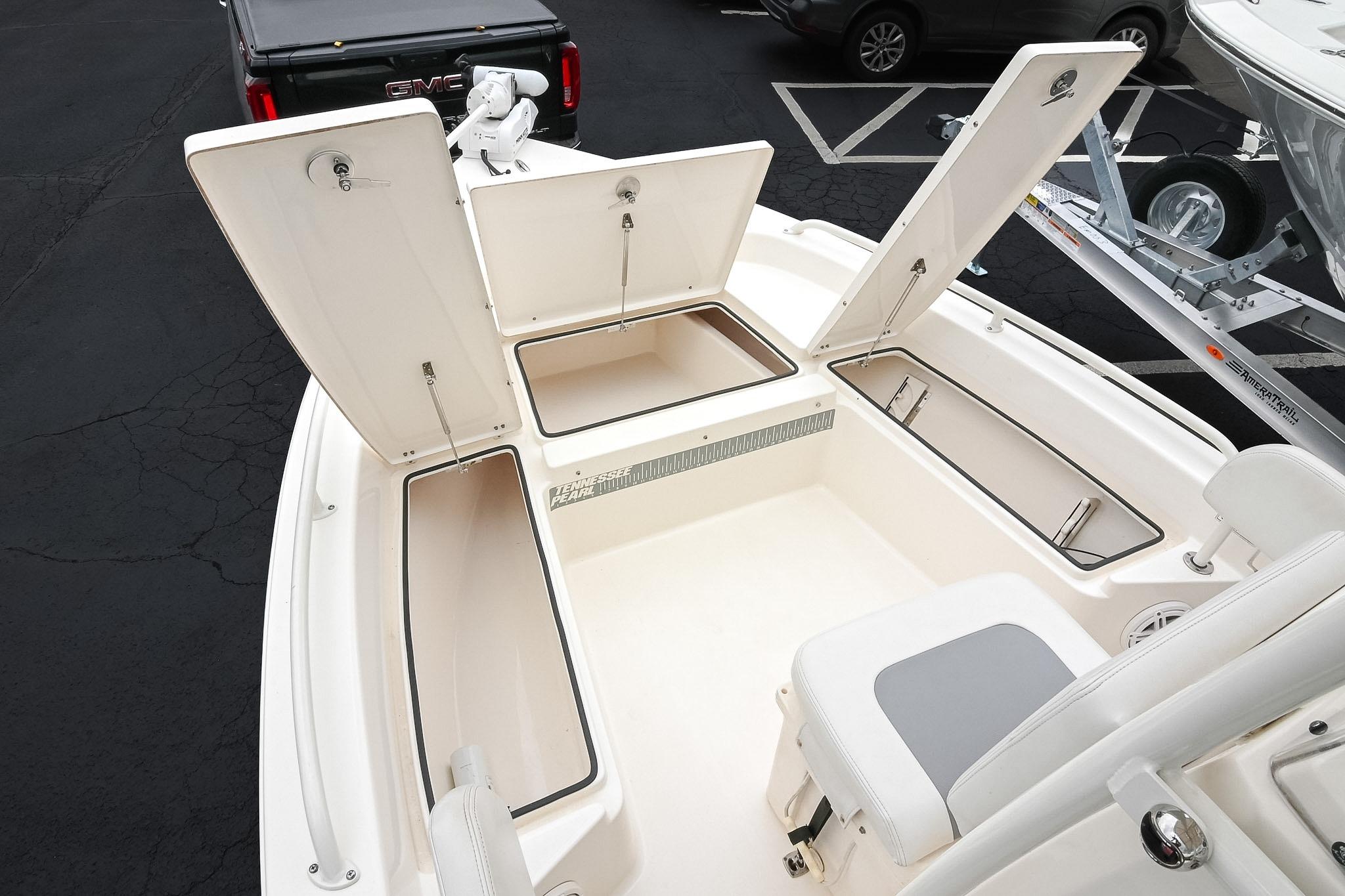 2021 Pathfinder 2200 TRS boat with open storage compartments, parked in a lot.