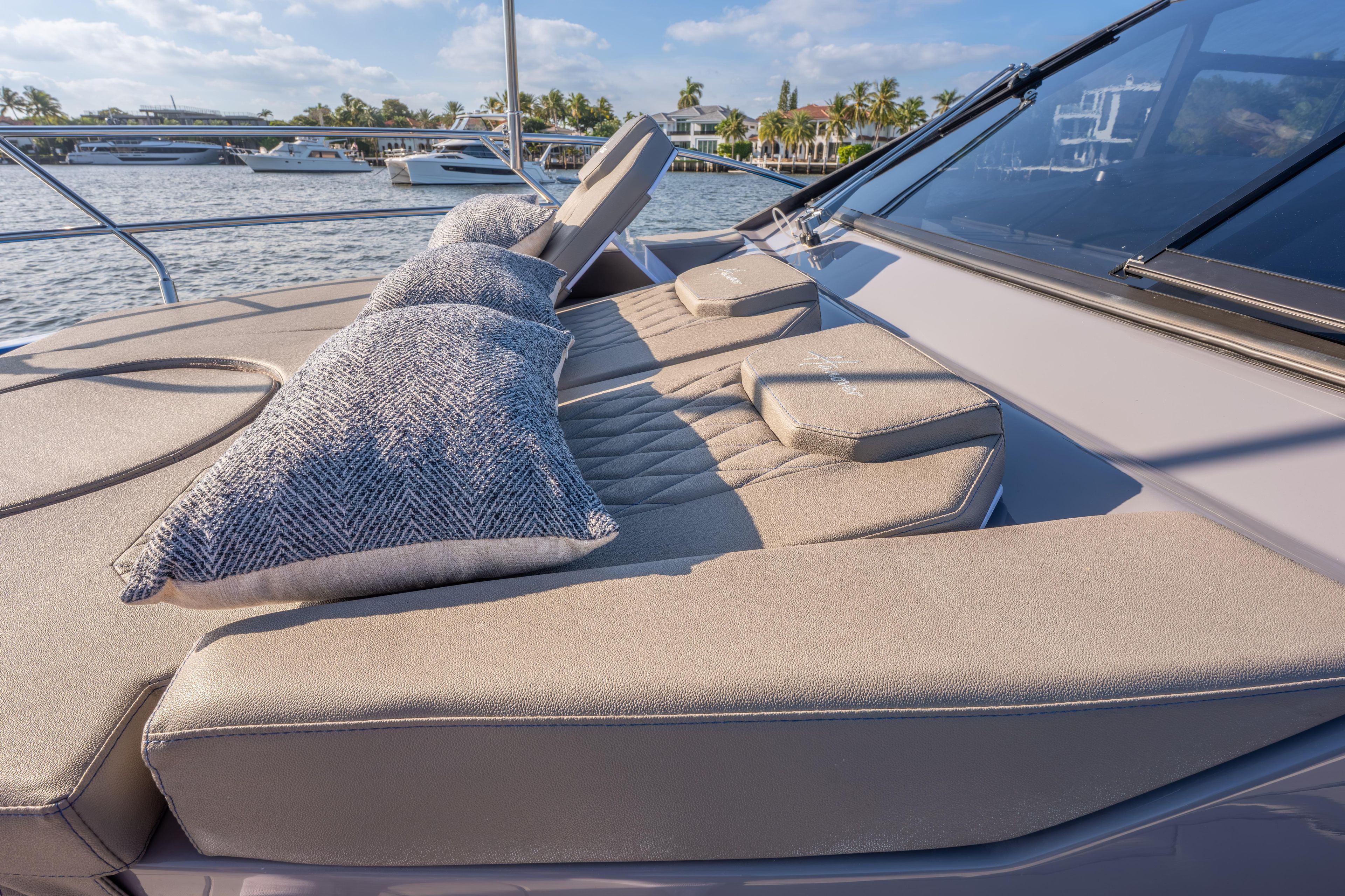 Luxurious Hanover 347 yacht deck with cushions, 2026 model, docked by waterfront homes.