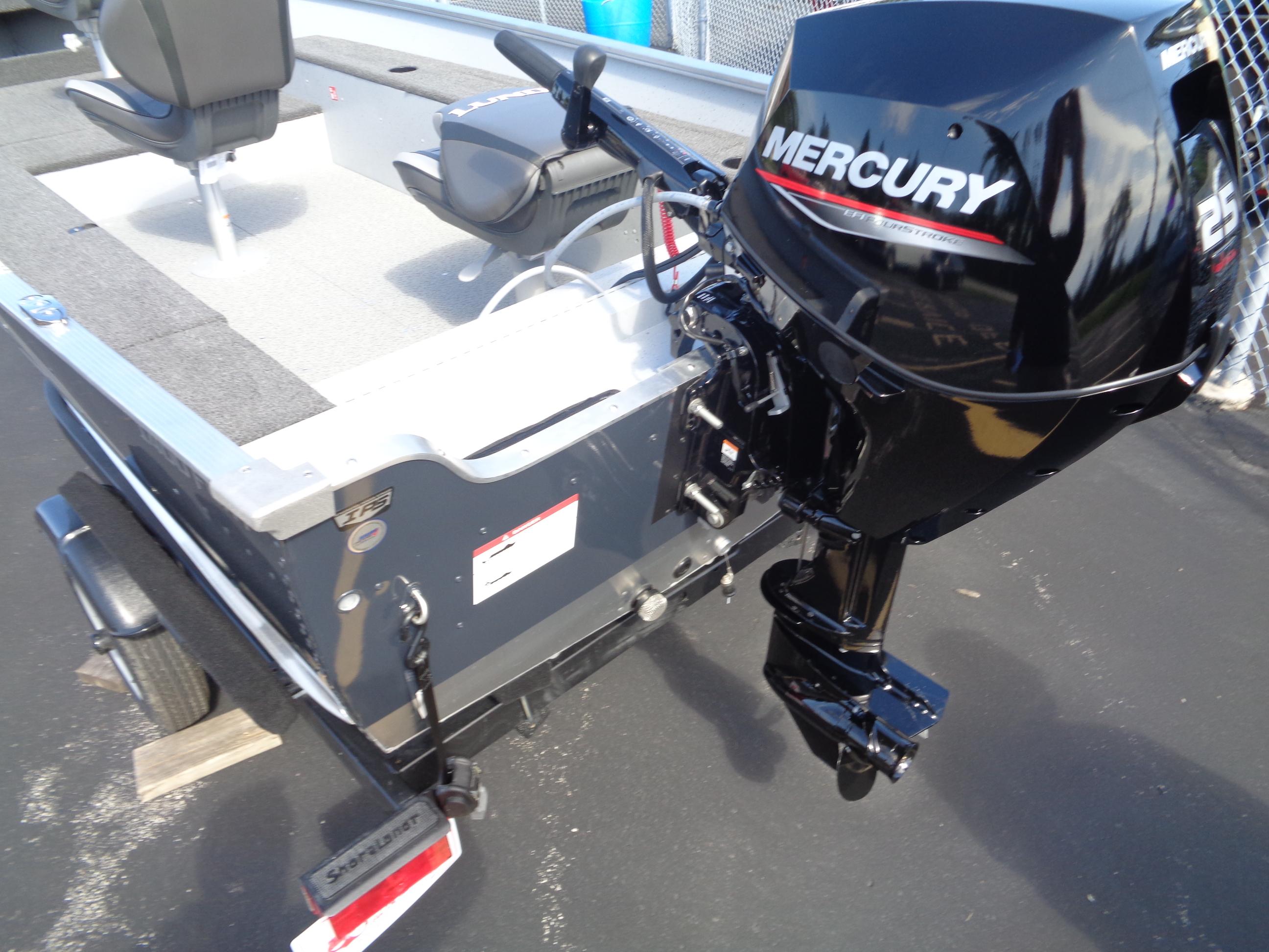 2025 Lund 1400 Fury Tiller boat with Mercury 25 HP outboard motor, parked on trailer.