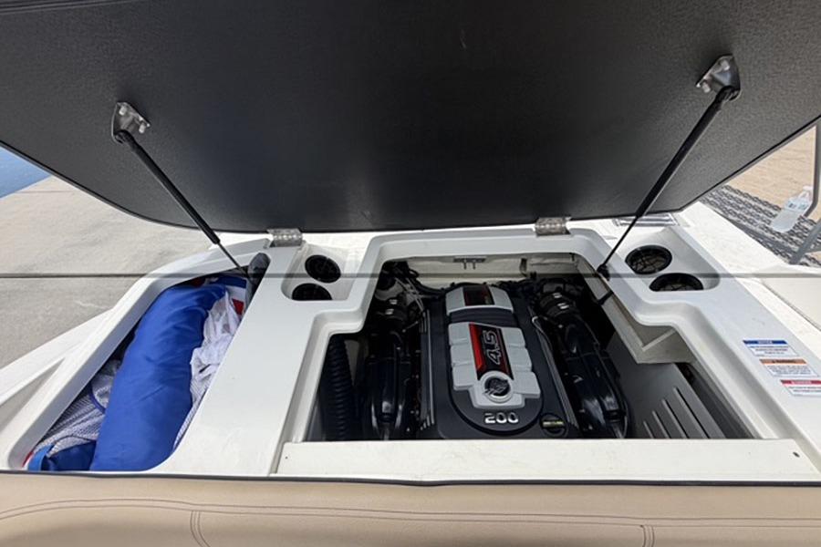 Open engine compartment of 2018 Sea Ray SPX 190 boat, showcasing the engine and storage area.