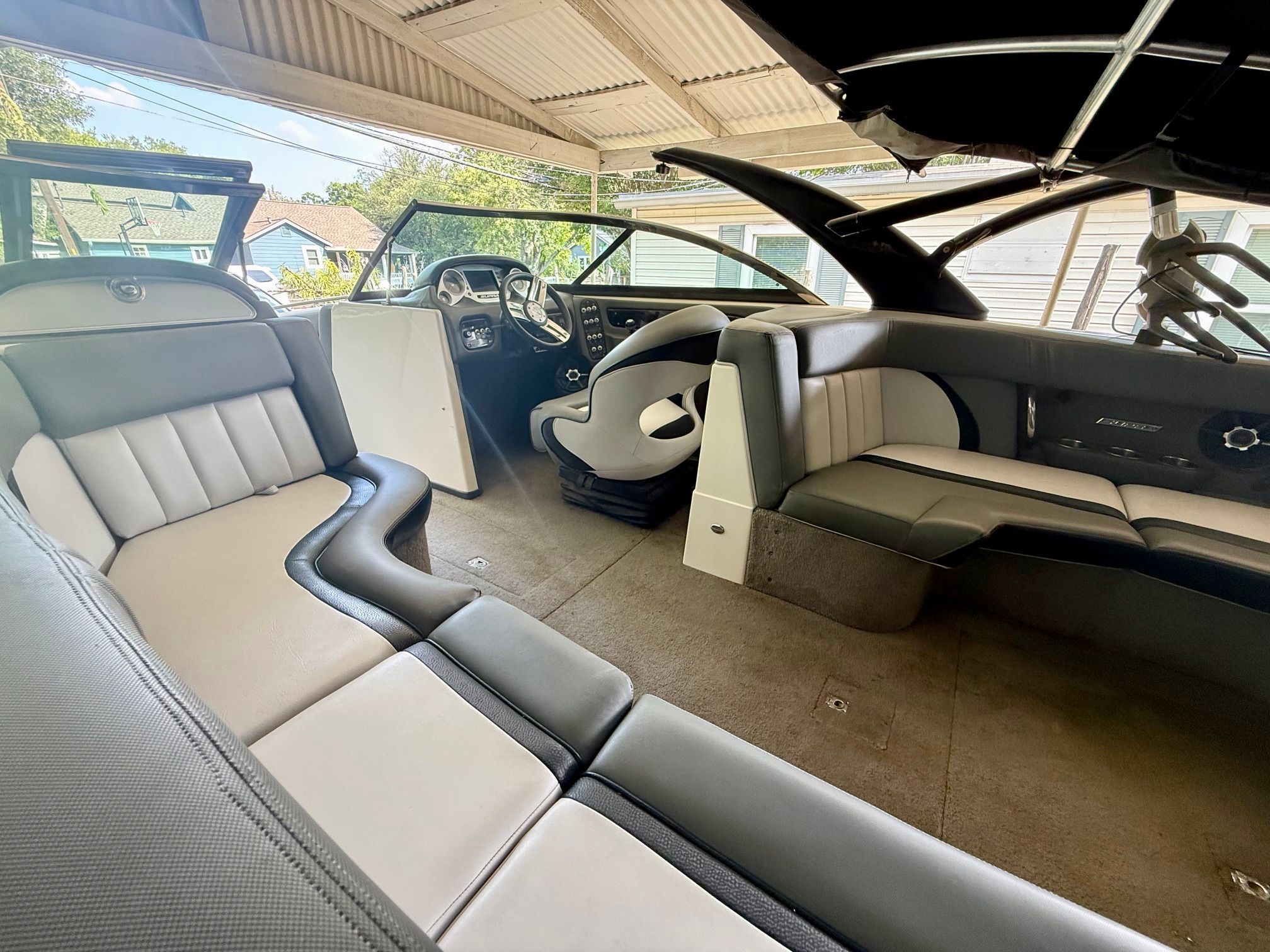 Interior view of a 2012 Supra Launch 242 boat with gray and white seating.
