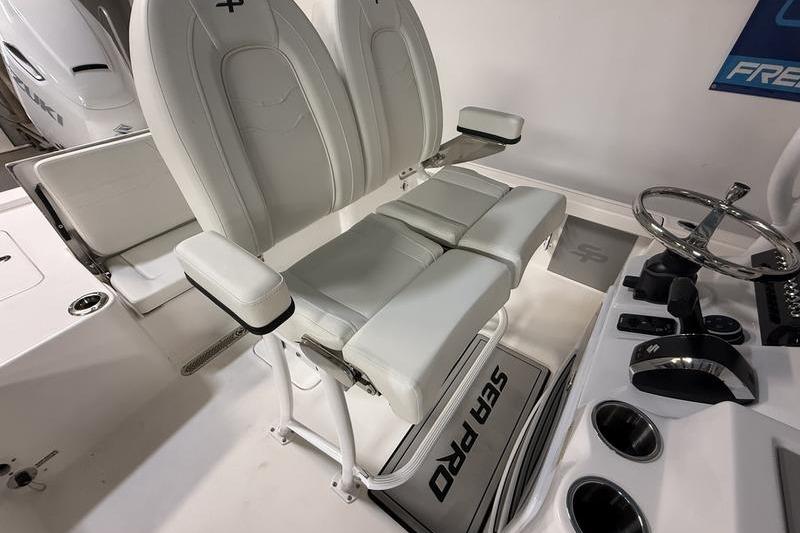 2026 Sea Pro 250 Bay boat interior with dual white captain's chairs and steering console.